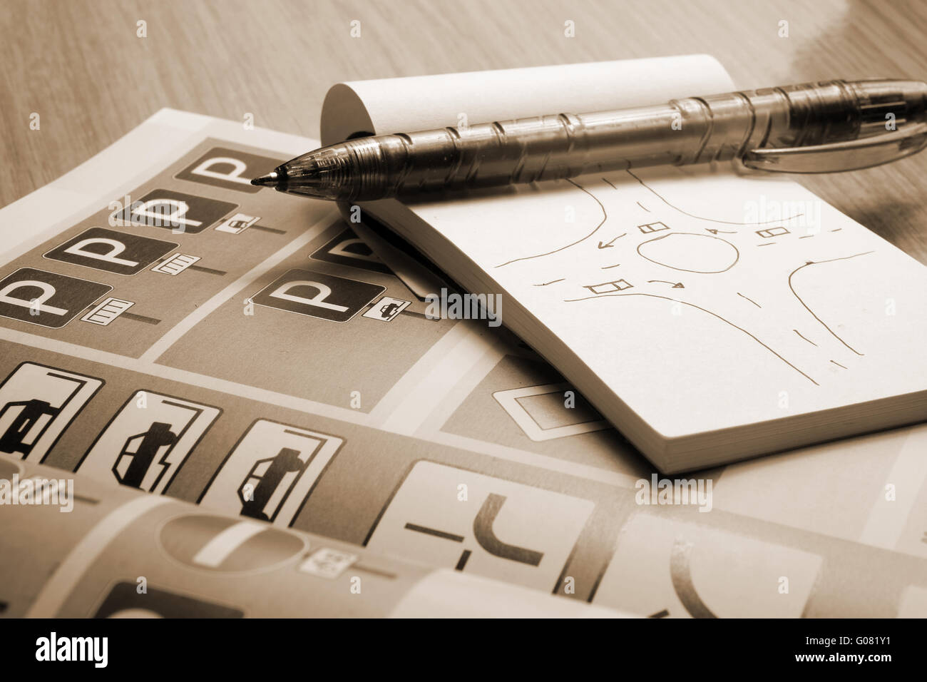 Blocco note, libro delle regole di traffico e penna su una scrivania. Studiare e preparare per il pilotaggio di esame di prova Foto Stock