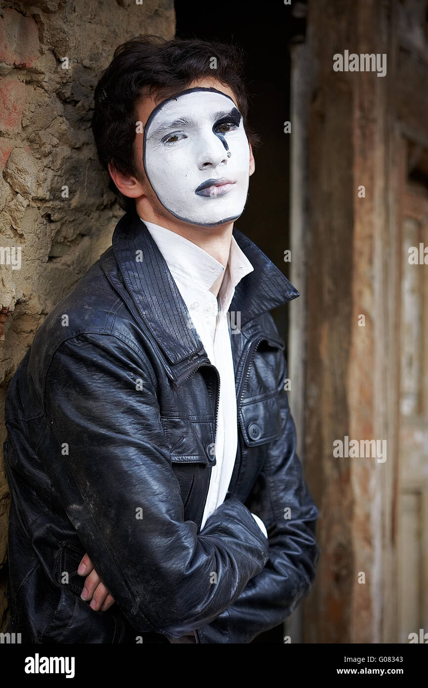 Guy mime contro un vecchio muro di mattoni. Foto Stock