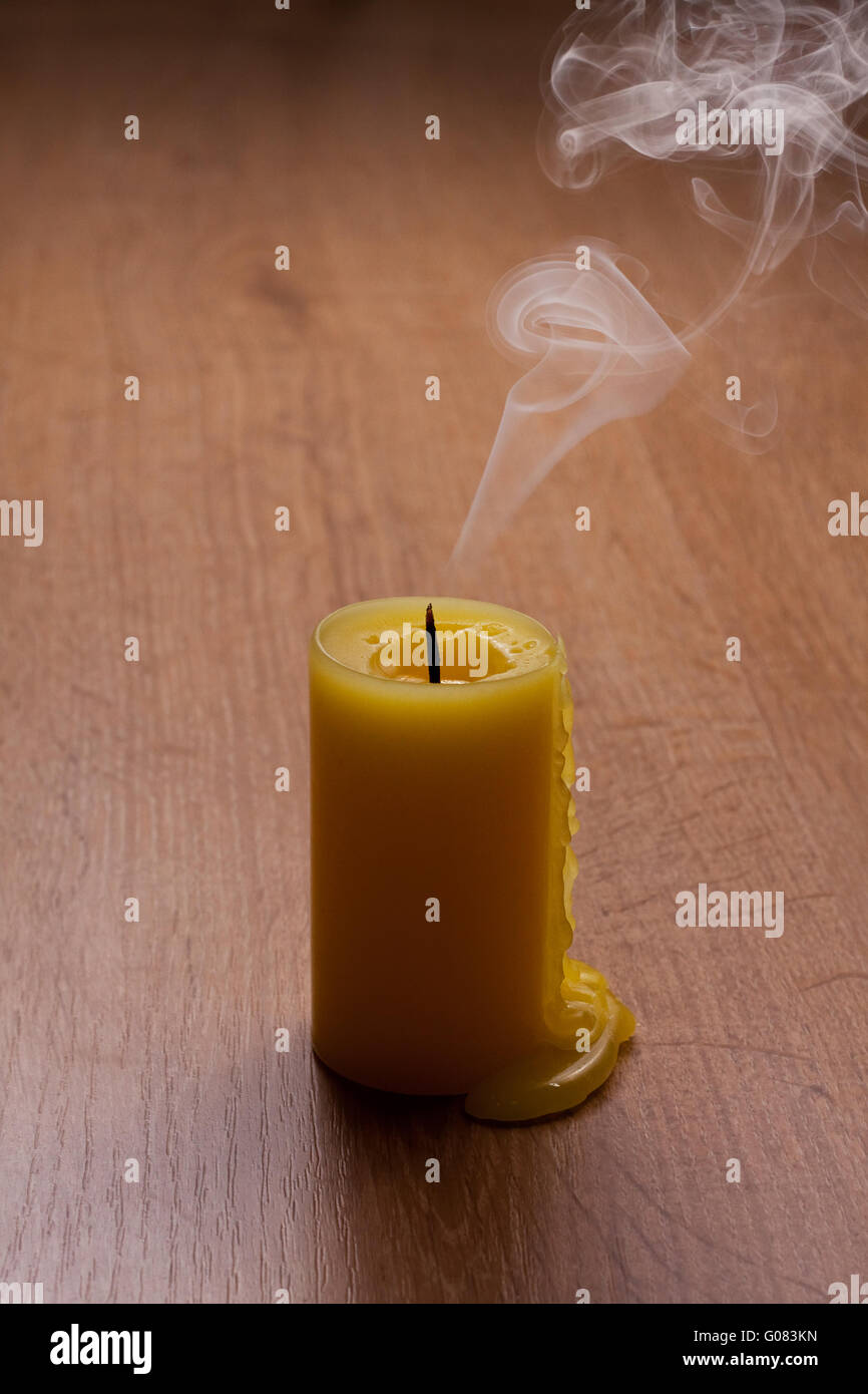 Uscì candela su un tavolo di legno con un sacco di fumo Foto Stock