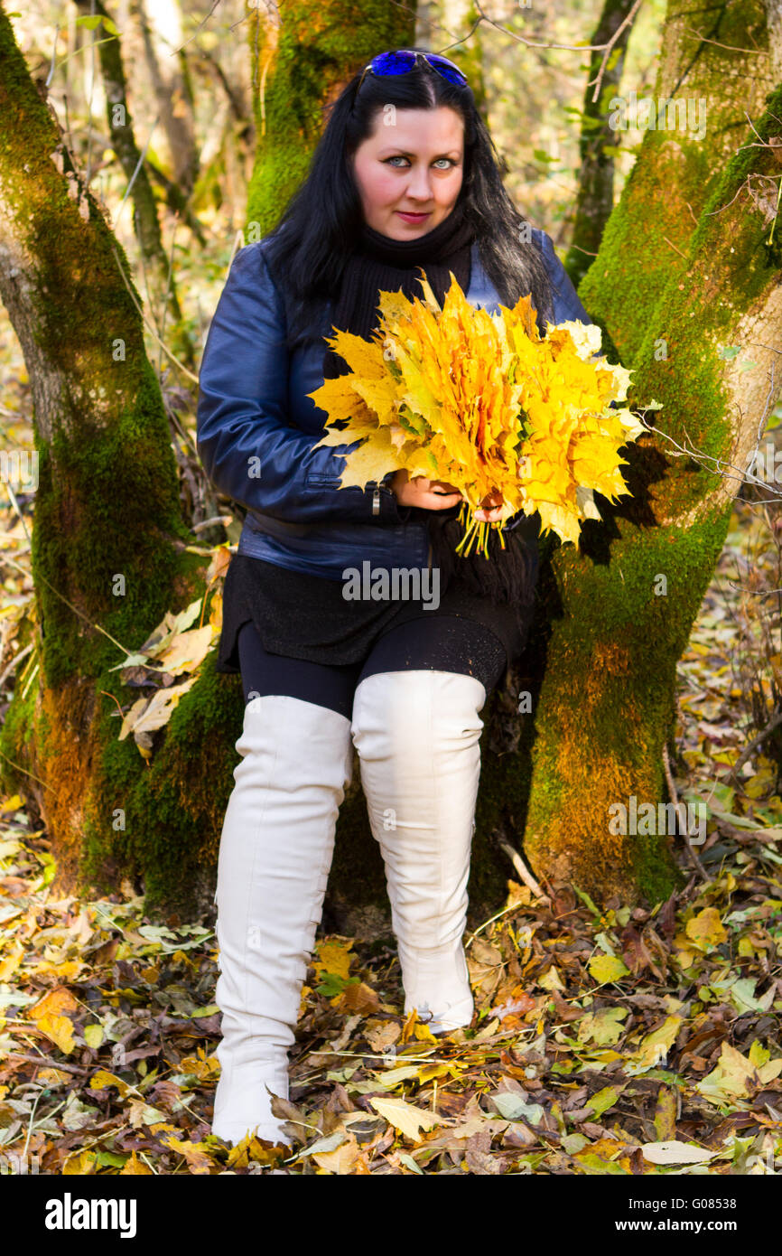 Autunno ragazza giocare nel parco della città. Caduta donna ritratto di felice bella e giovane e bella donna nel bosco in Autunno colori Foto Stock