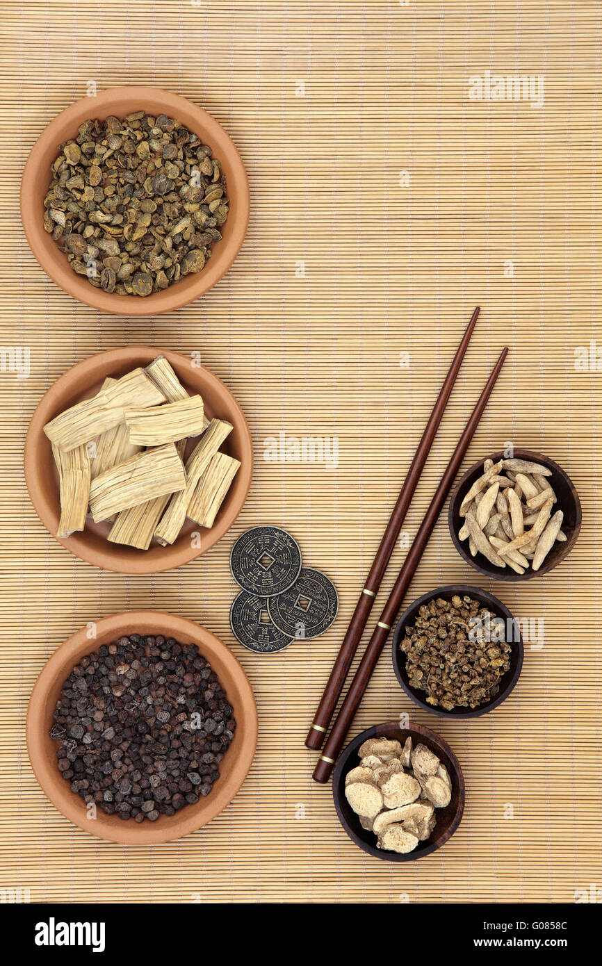 Cinese tradizionale herb ingredienti usati nella medicina alternativa, i Ching monete e bacchette su sfondo di bambù. Foto Stock