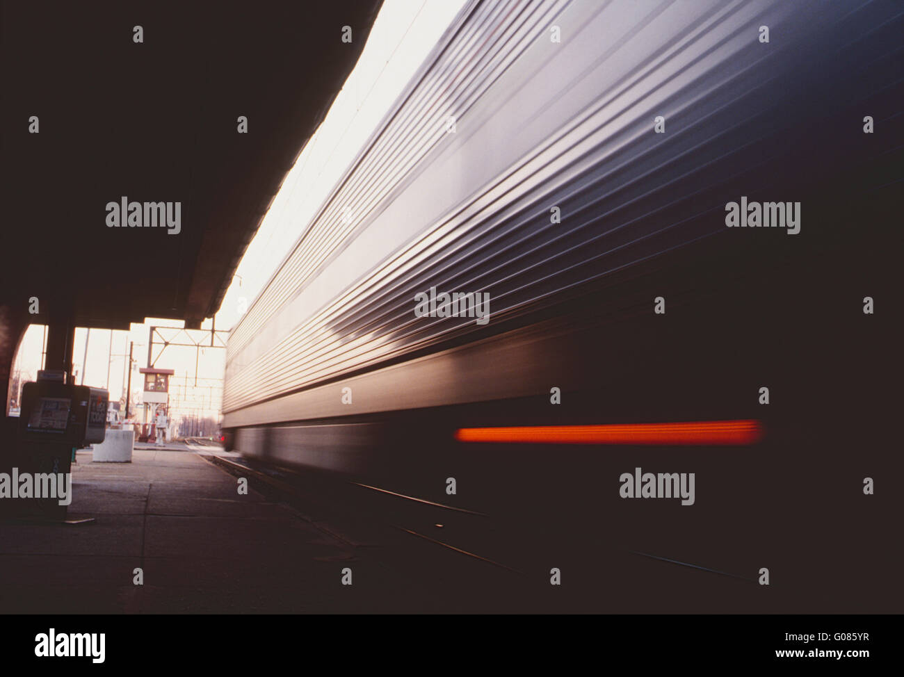 Pan blur motion view di setti commuter train auto lasciando la stazione Foto Stock