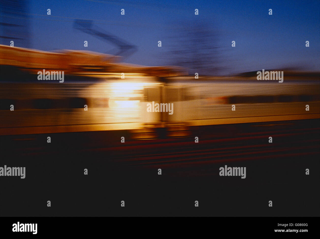 Pan motion blur vista di impostazione di sole riflesso di setti commuter train car Foto Stock