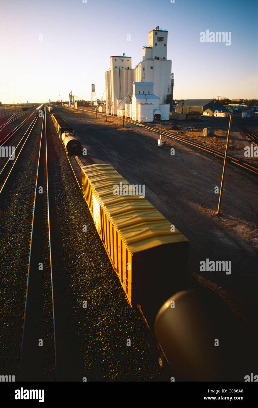 Industriali di grandi dimensioni cantiere ferroviario & elevatori della granella al tramonto; Clovis; Nuovo Messico e Stati Uniti d'America Foto Stock