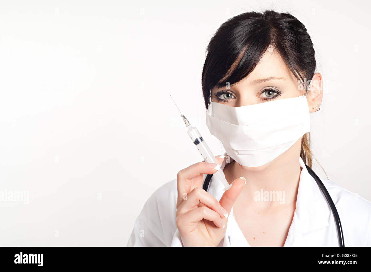 Ritratto di donna medico con una siringa, isolato su sfondo bianco Foto Stock