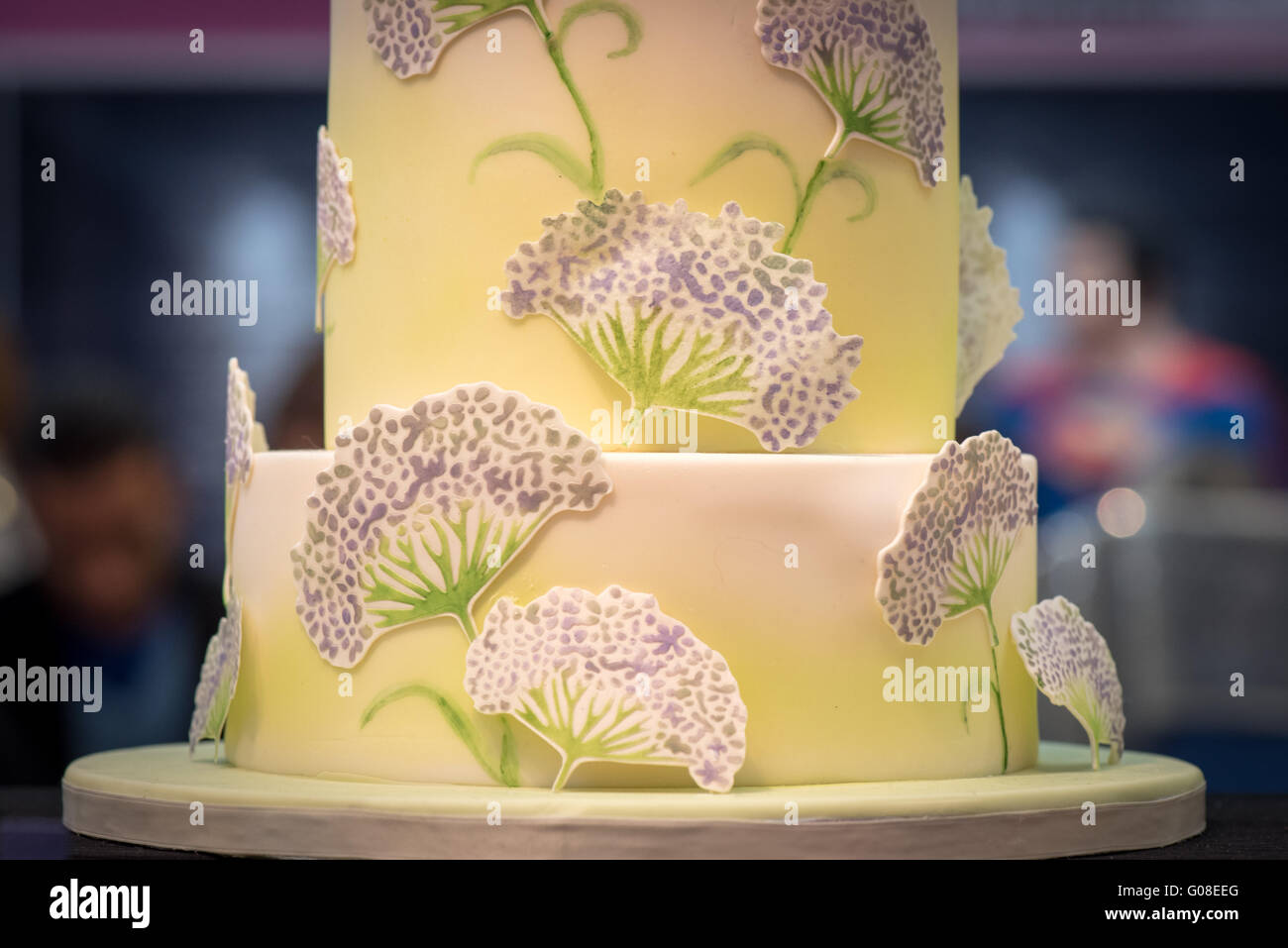 Giallo a strati la torta di nozze con fiori viola, torta International - La Sugarcraft, torta decorazione e cottura mostra a Londra Foto Stock
