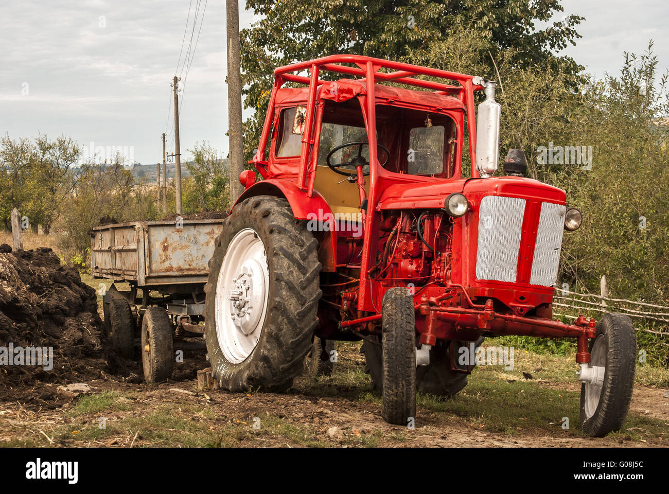 Rosso Vintage grunge trattore sul paesaggio rurale Foto Stock