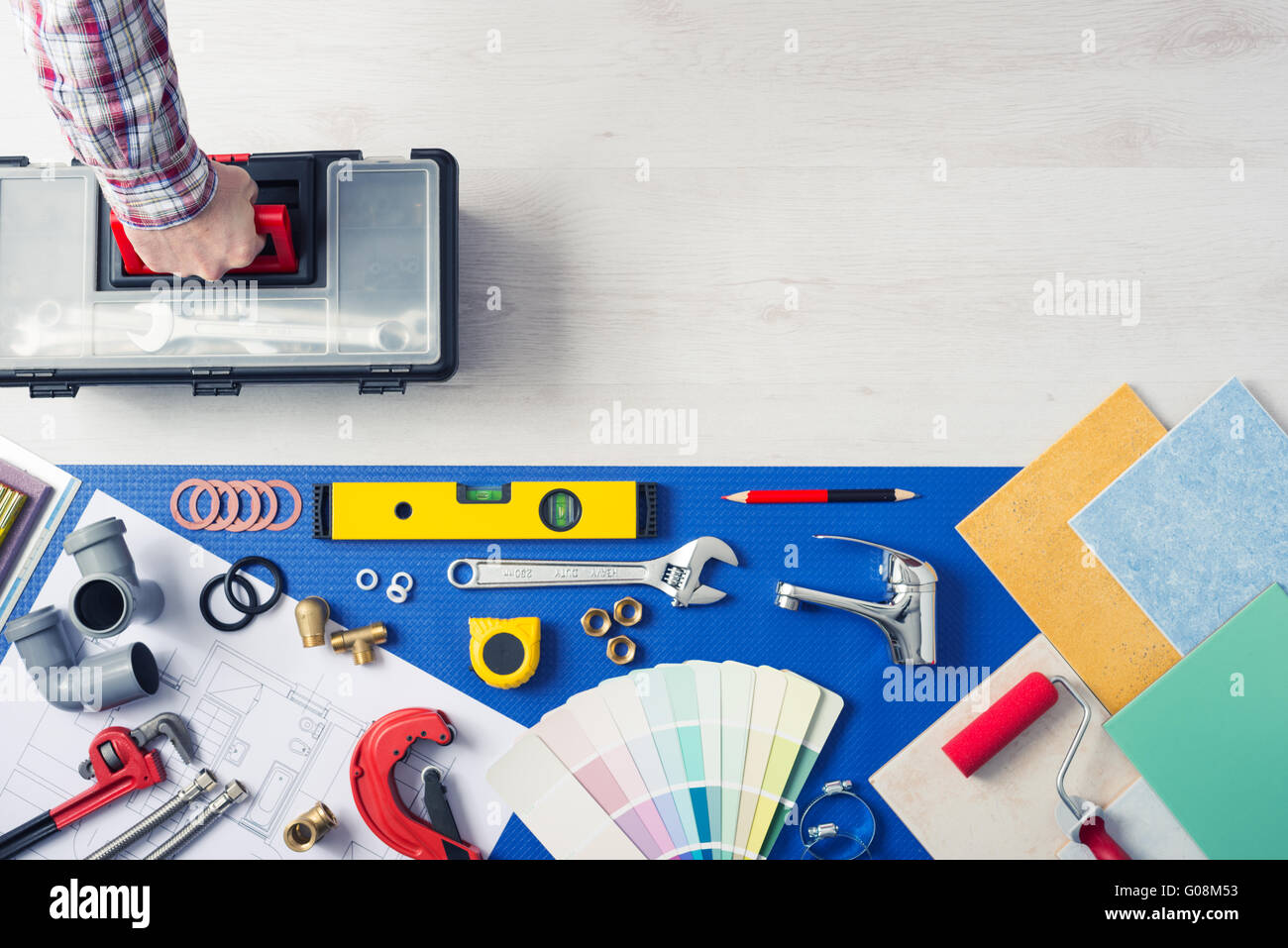 Repairman portando una cassetta degli attrezzi con utensili per idraulici, piastrelle e campioni di colore top view, home concetto di servizio Foto Stock