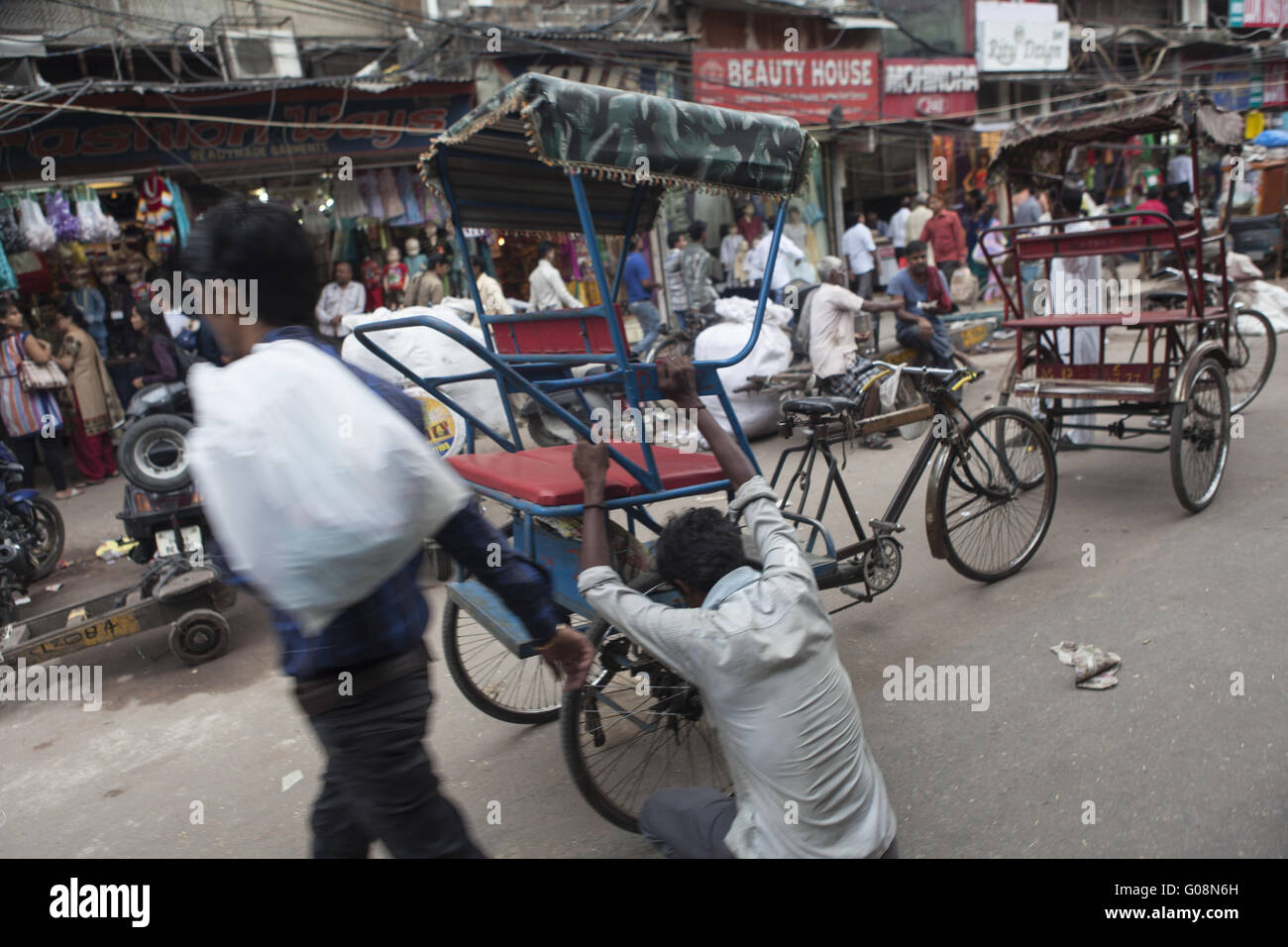 In rickshaw driver accucciato giù, Old-Dehli, India Foto Stock