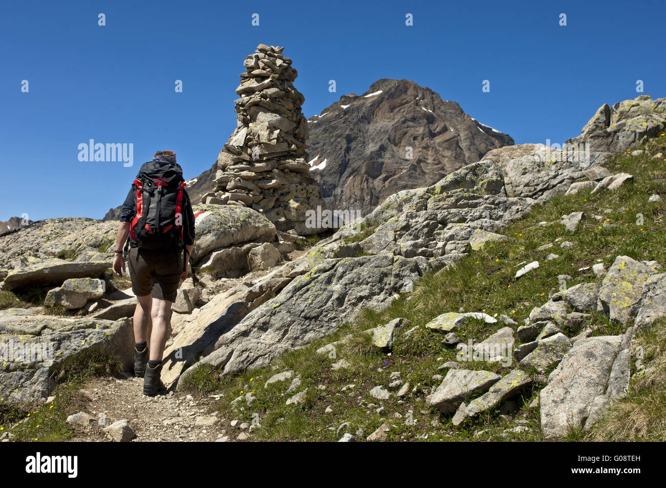 Escursionista presso un tumulo sul sentiero escursionistico, Vallese Foto Stock