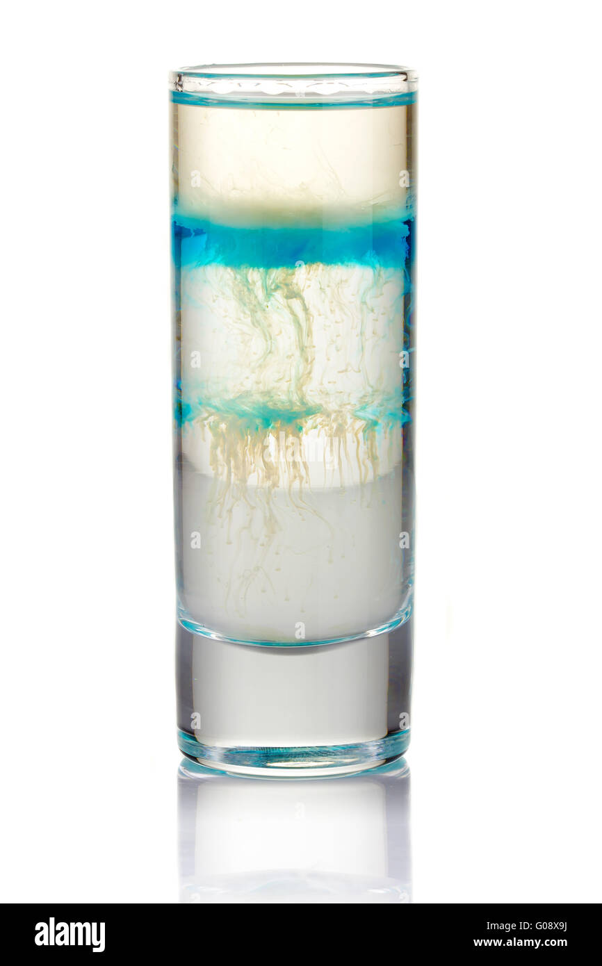 Girato a fette cocktail alcolici con gocce di blu isolato su bianco Foto Stock