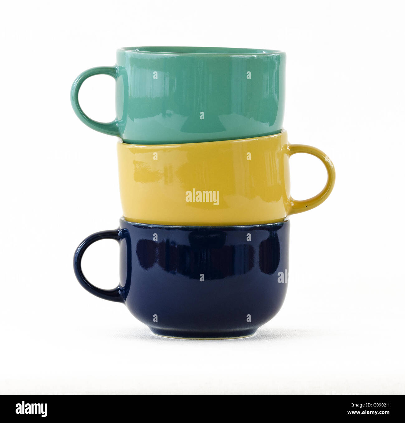 Tre tazze con manici di giallo, verde e blu Foto Stock