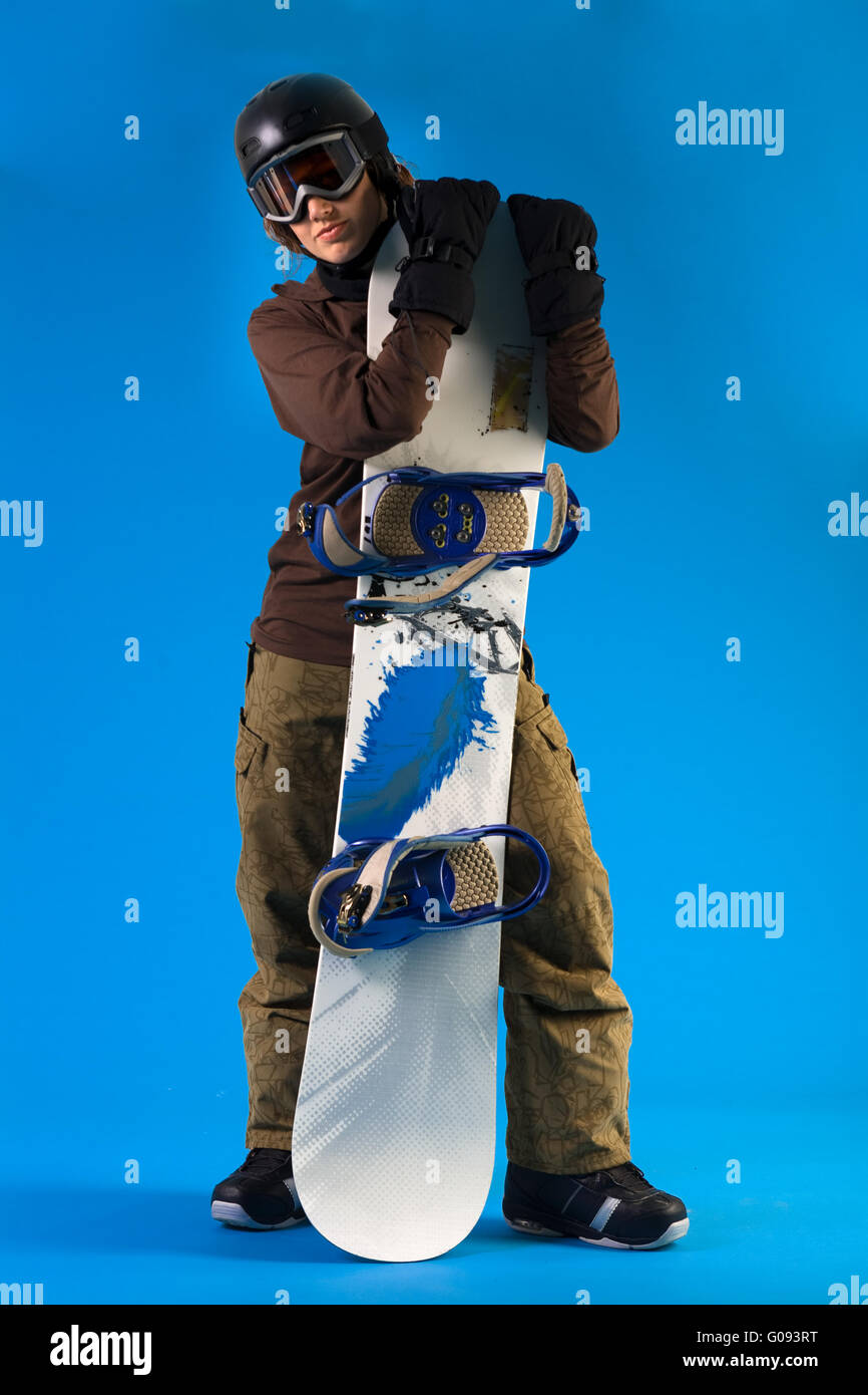 Donna con lunghi capelli ricci presentando il suo snowboard Foto Stock