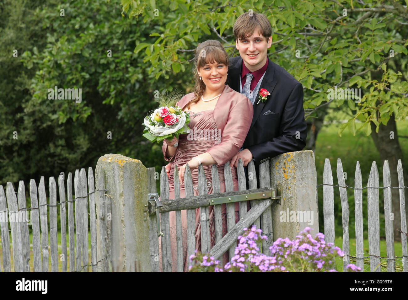 Sposa e lo sposo in autunno a legno cancello del giardino Foto Stock
