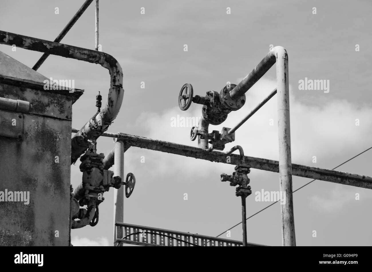 Tubi, rubinetti e un serbatoio di ruggine, dettaglio da un abbandonato ice cream factory Foto Stock