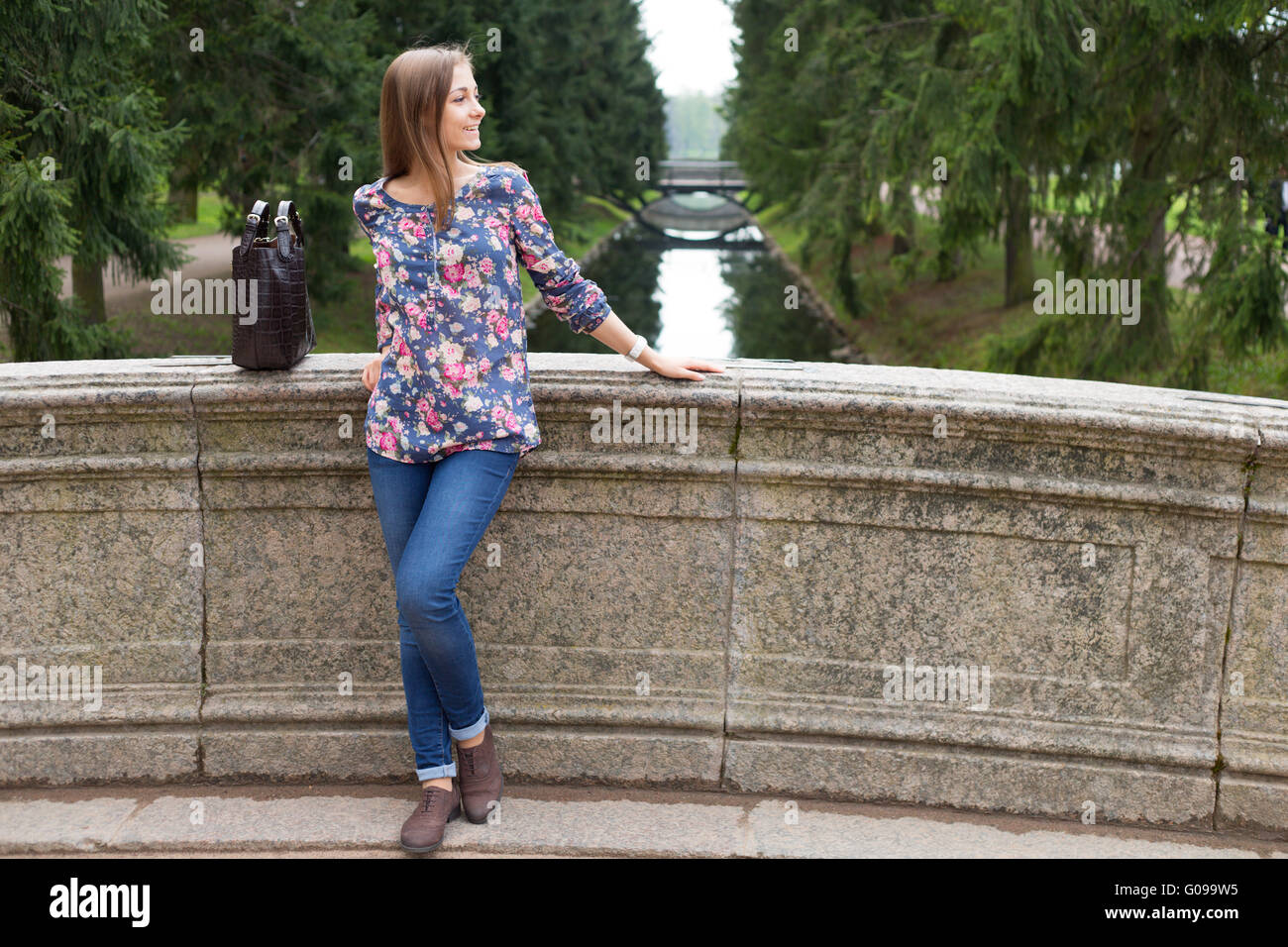 Giovane e bella ragazza sul vecchio ponte in pietra Foto Stock