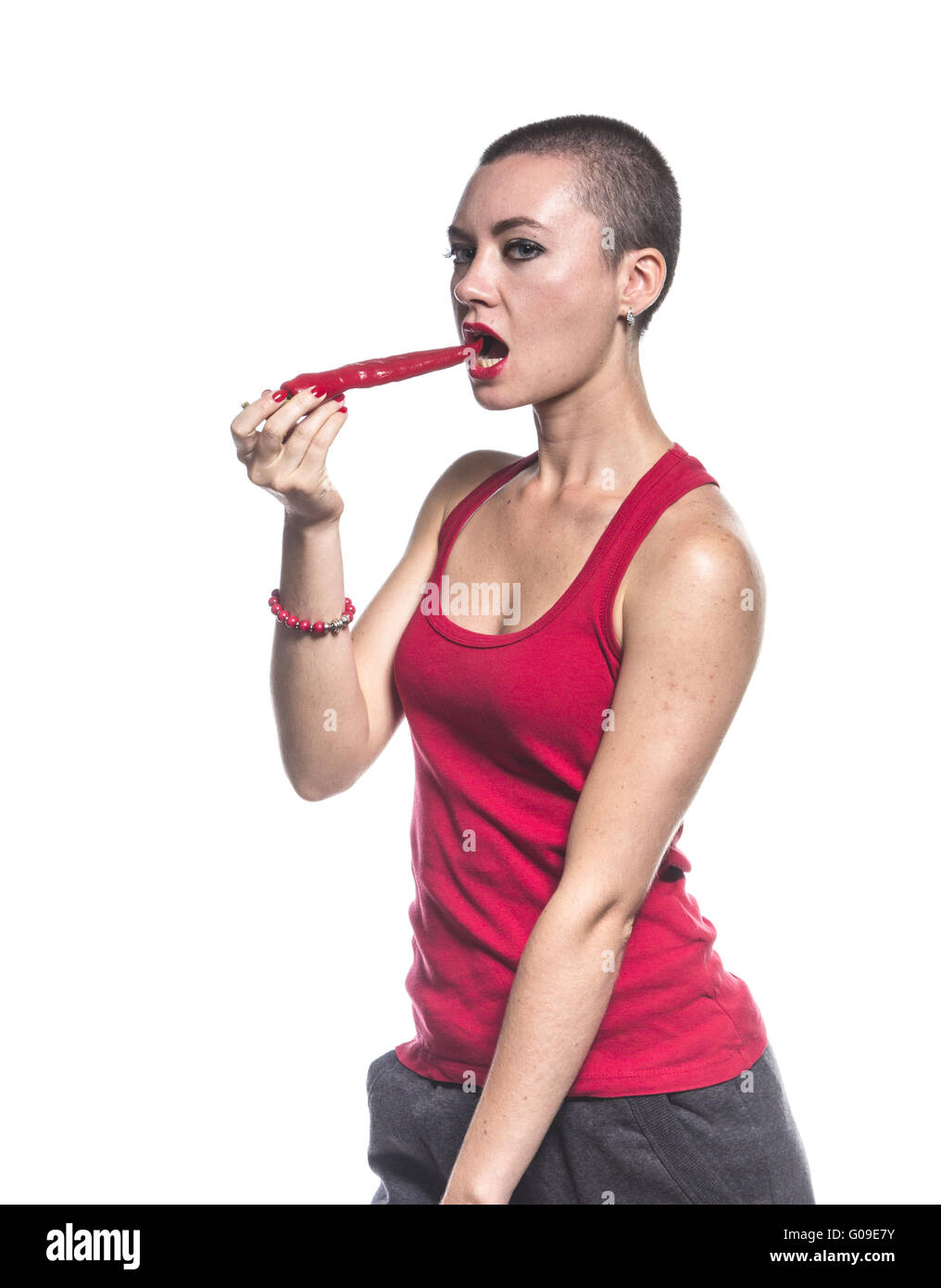 Donna di mangiare peperoncino su sfondo bianco Foto Stock