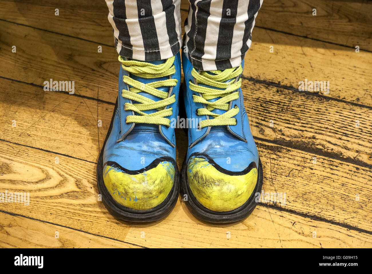 Gambe femmina con scarpe colorate sul pavimento in legno Foto Stock