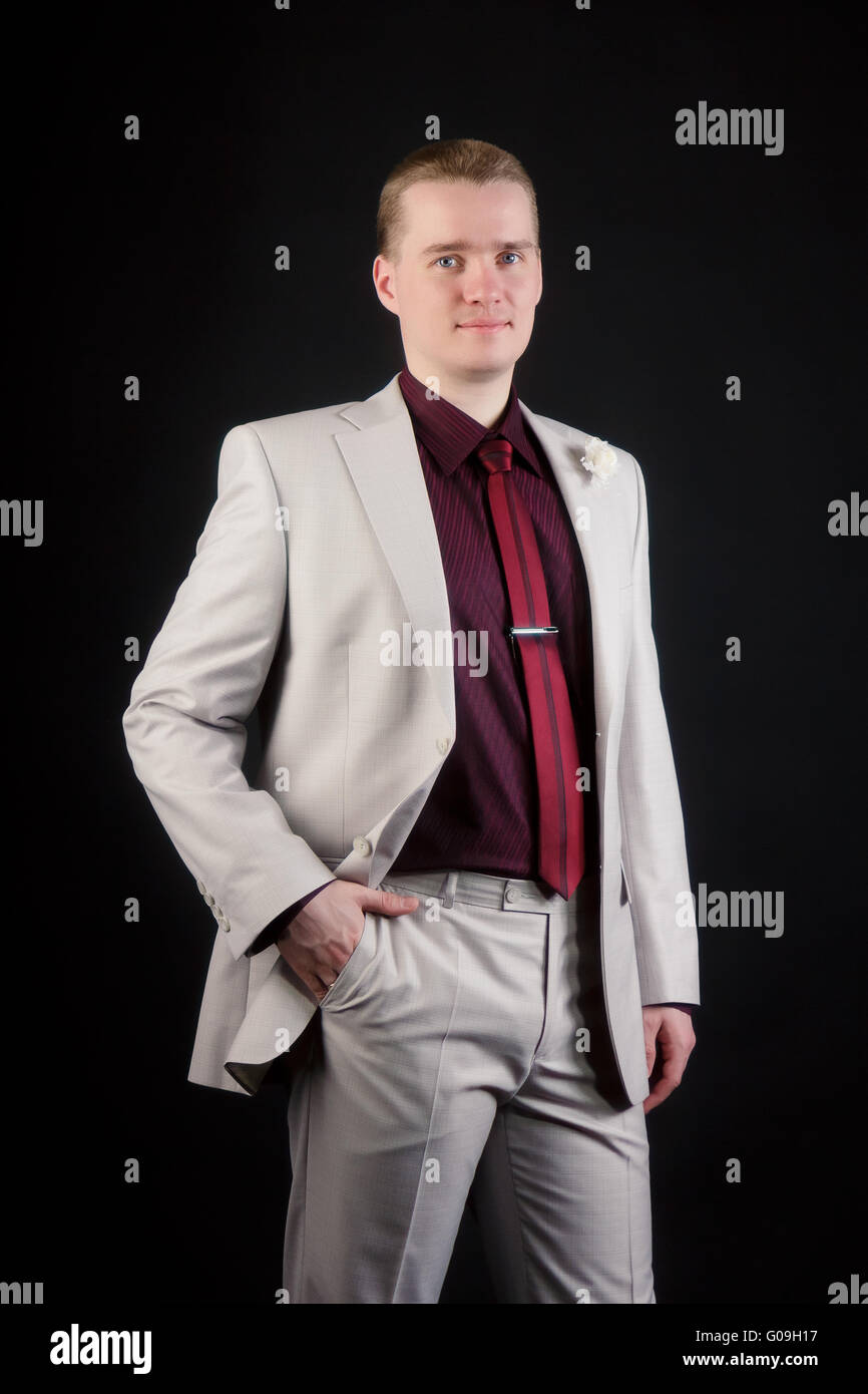 Giovane uomo attraente in una luce indossare giacca e cravatta Foto Stock