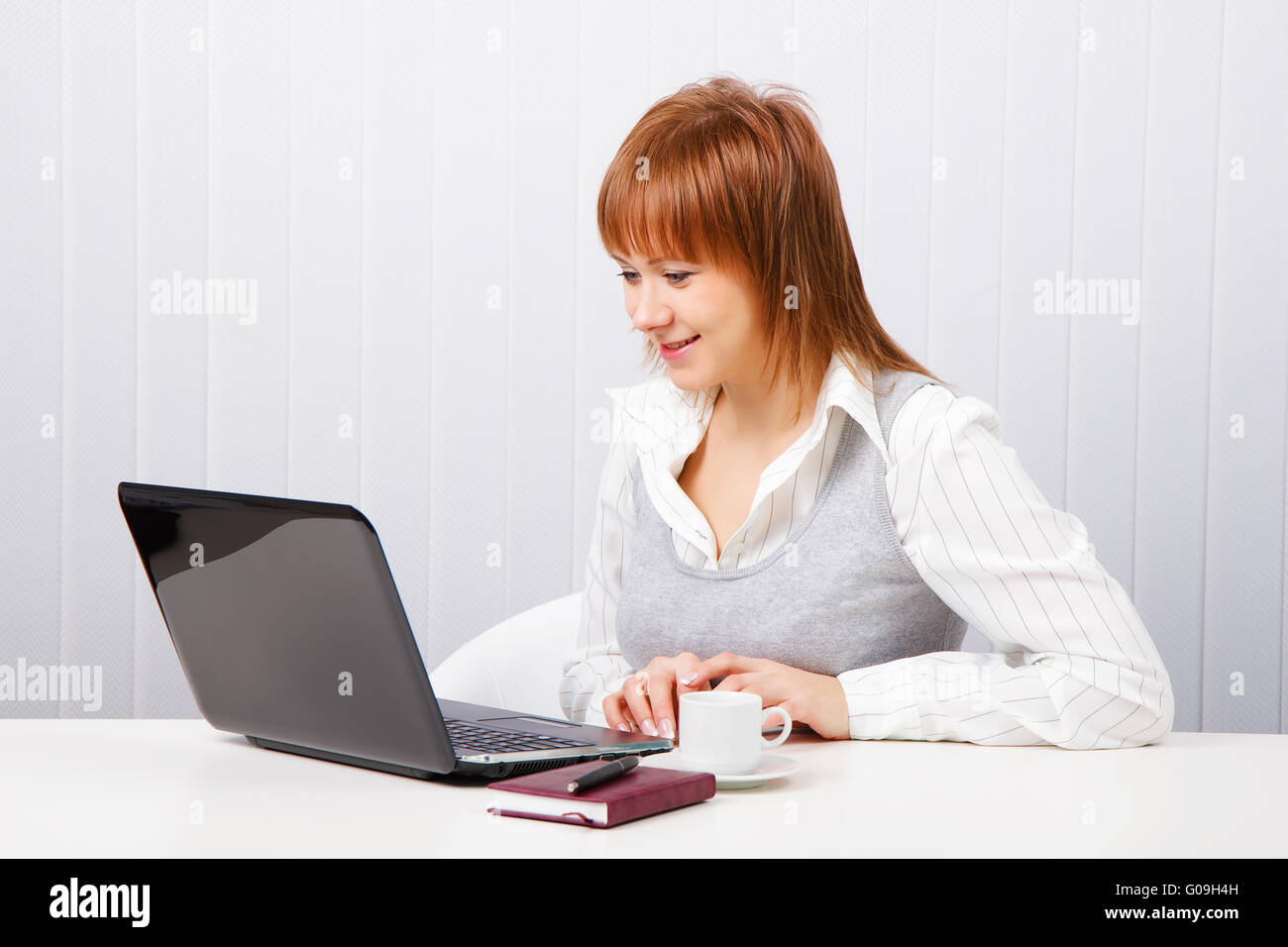 Sorridente ragazza attraente con un notebook. Lavoratore di ufficio Foto Stock