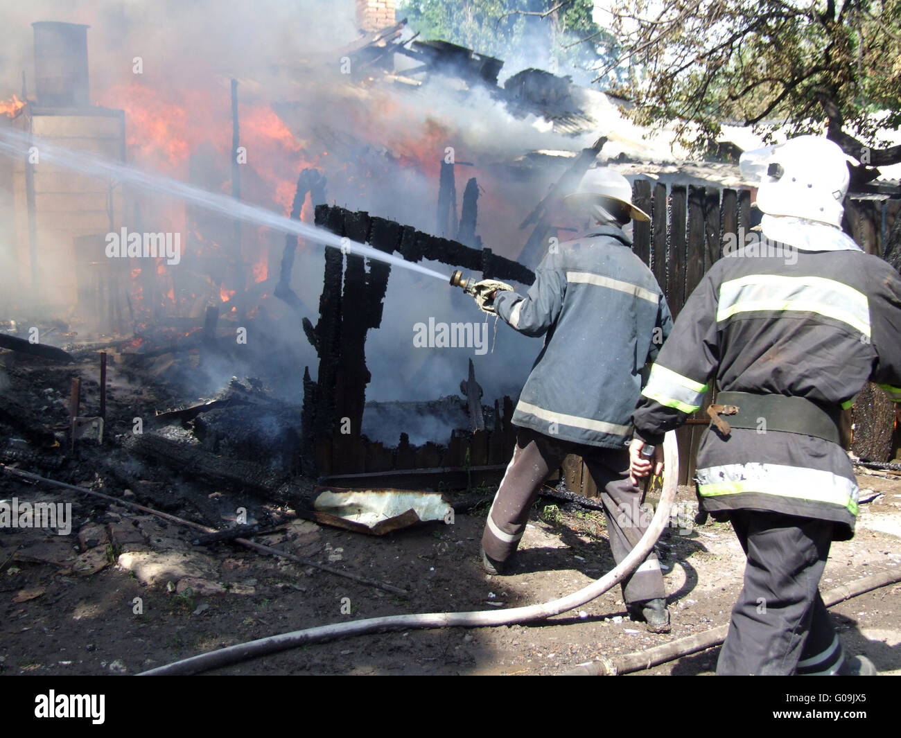 Vigile del fuoco la spruzzatura di acqua i pompieri spengono un incendio in un apartment house Foto Stock