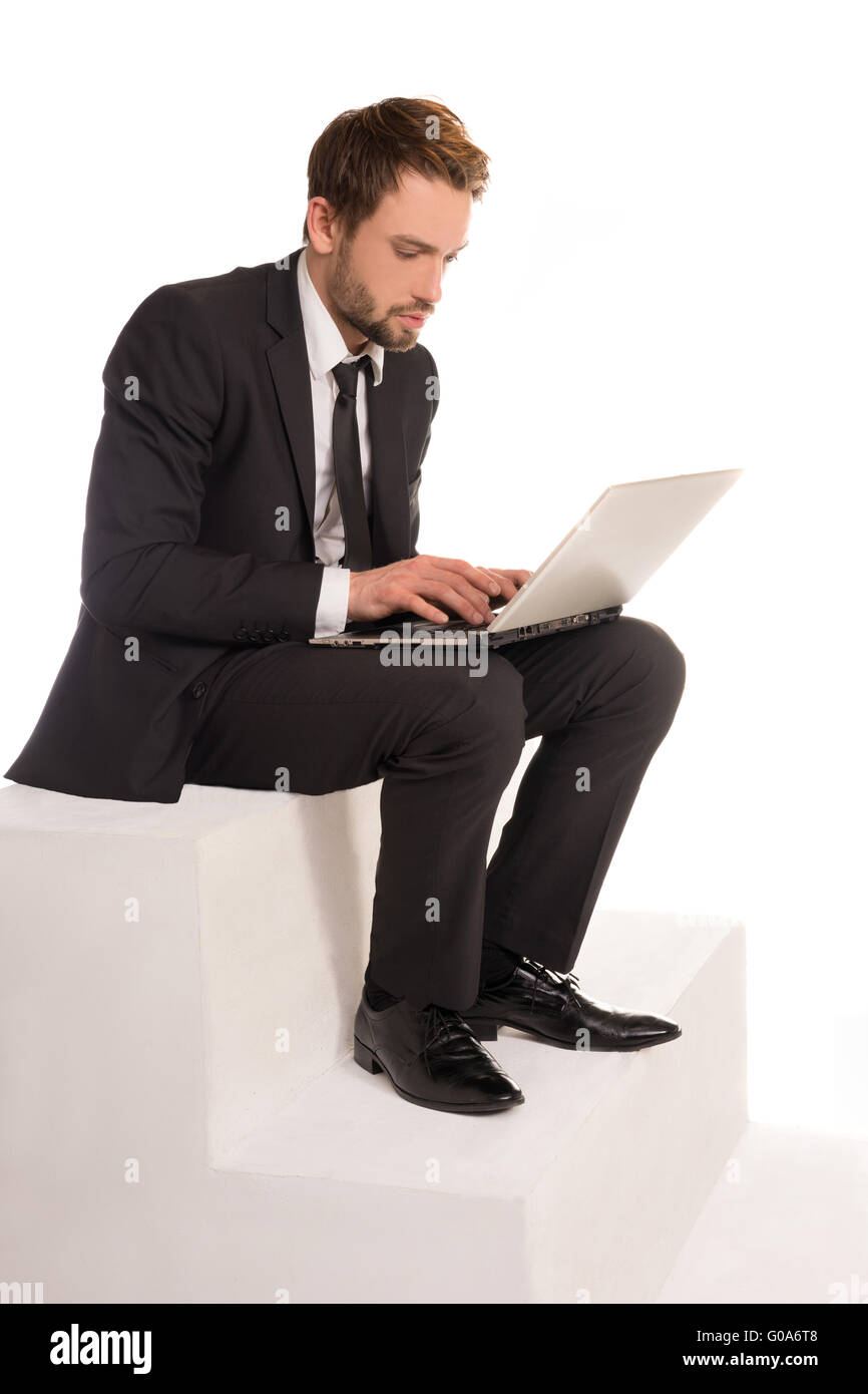 Imprenditore seduto su una scala al lavoro su un notebook Foto Stock