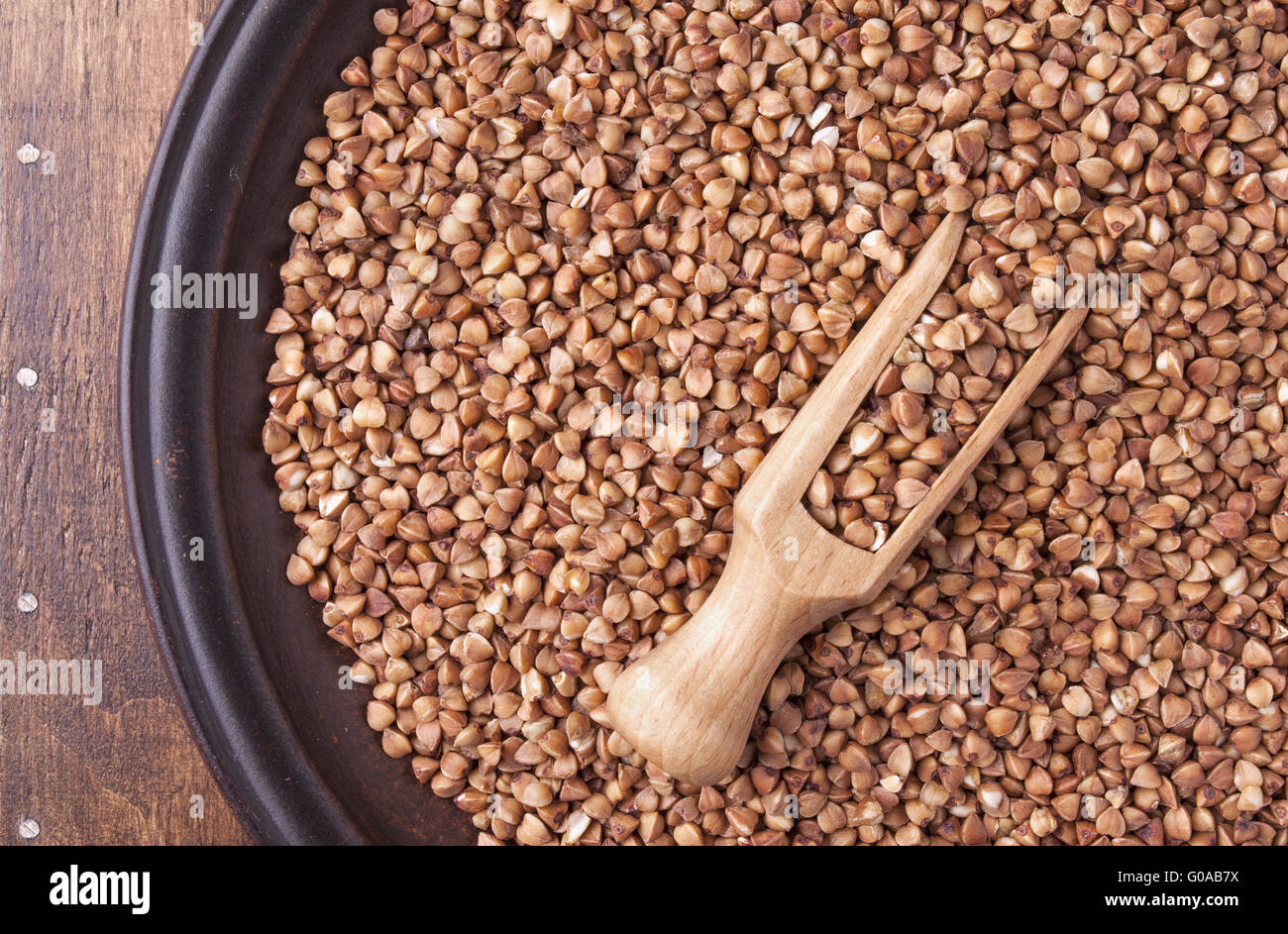 Organici di semole e semolini di grano saraceno in piastra su legno scuro dello sfondo Foto Stock