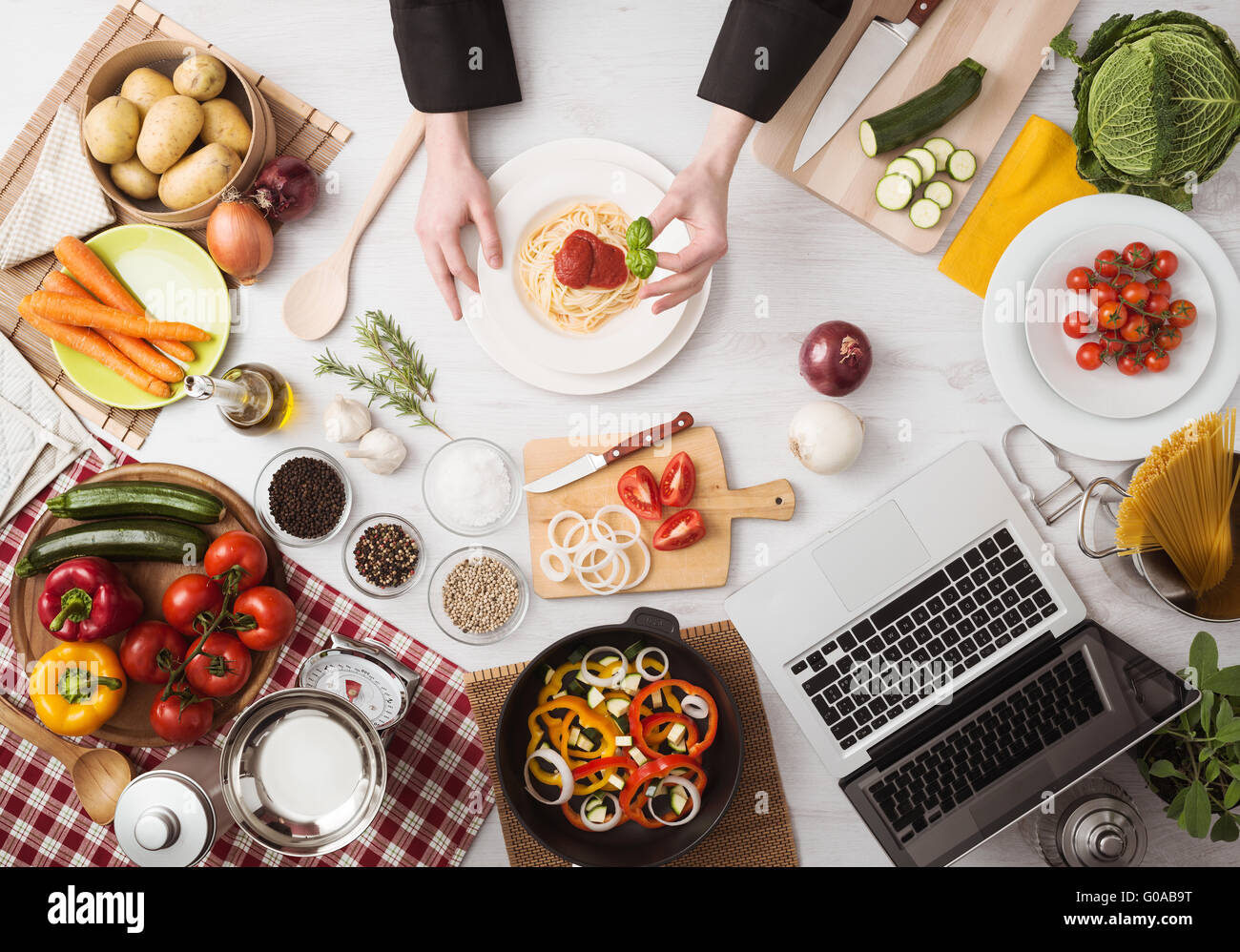 Chef professionale con le mani in mano la cottura della pasta su un piano di lavoro in legno con verdure, degli ingredienti alimentari e utensili, vista dall'alto Foto Stock