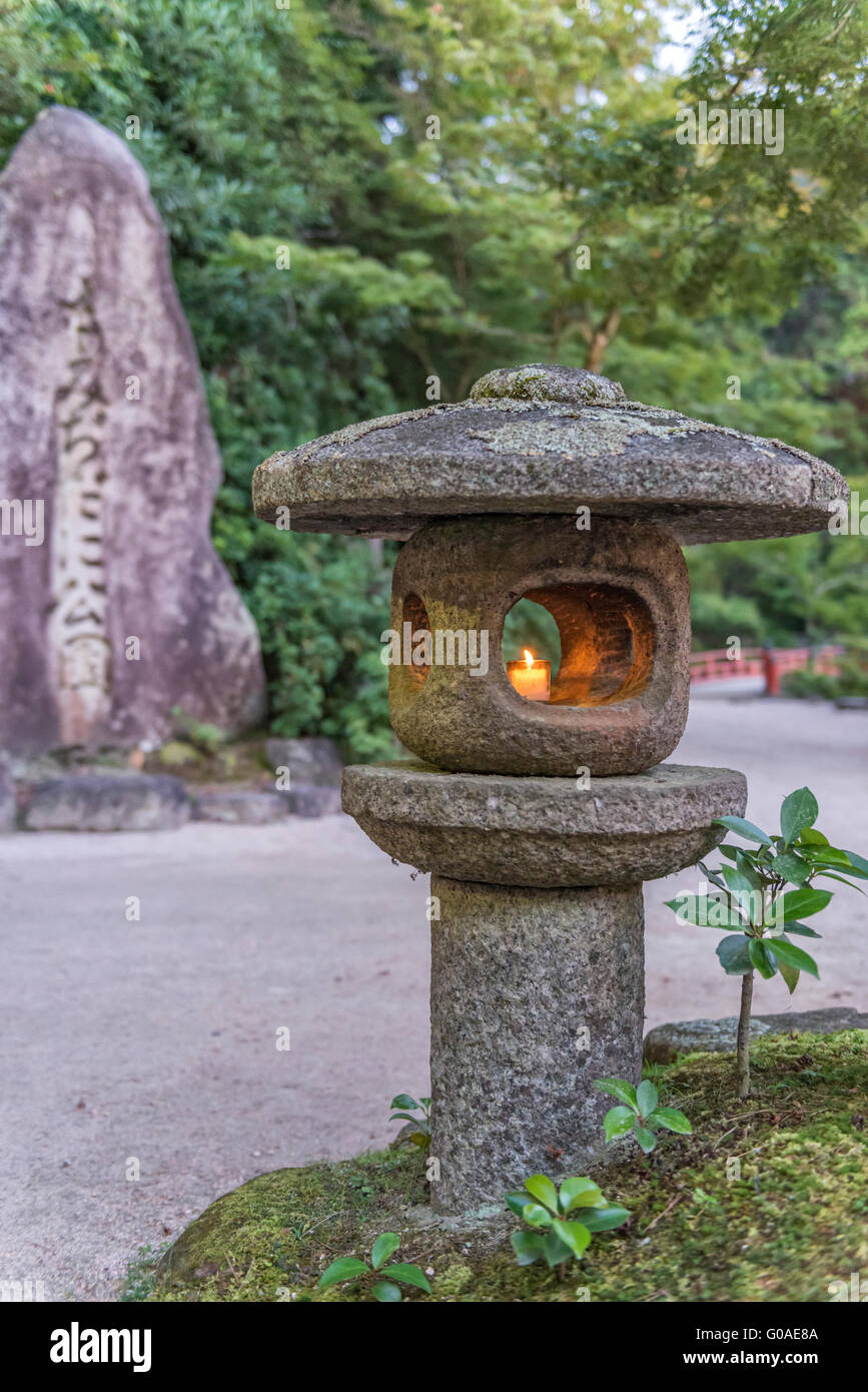 Candela brucia in un oriental pietra ornamentale lampada Foto Stock