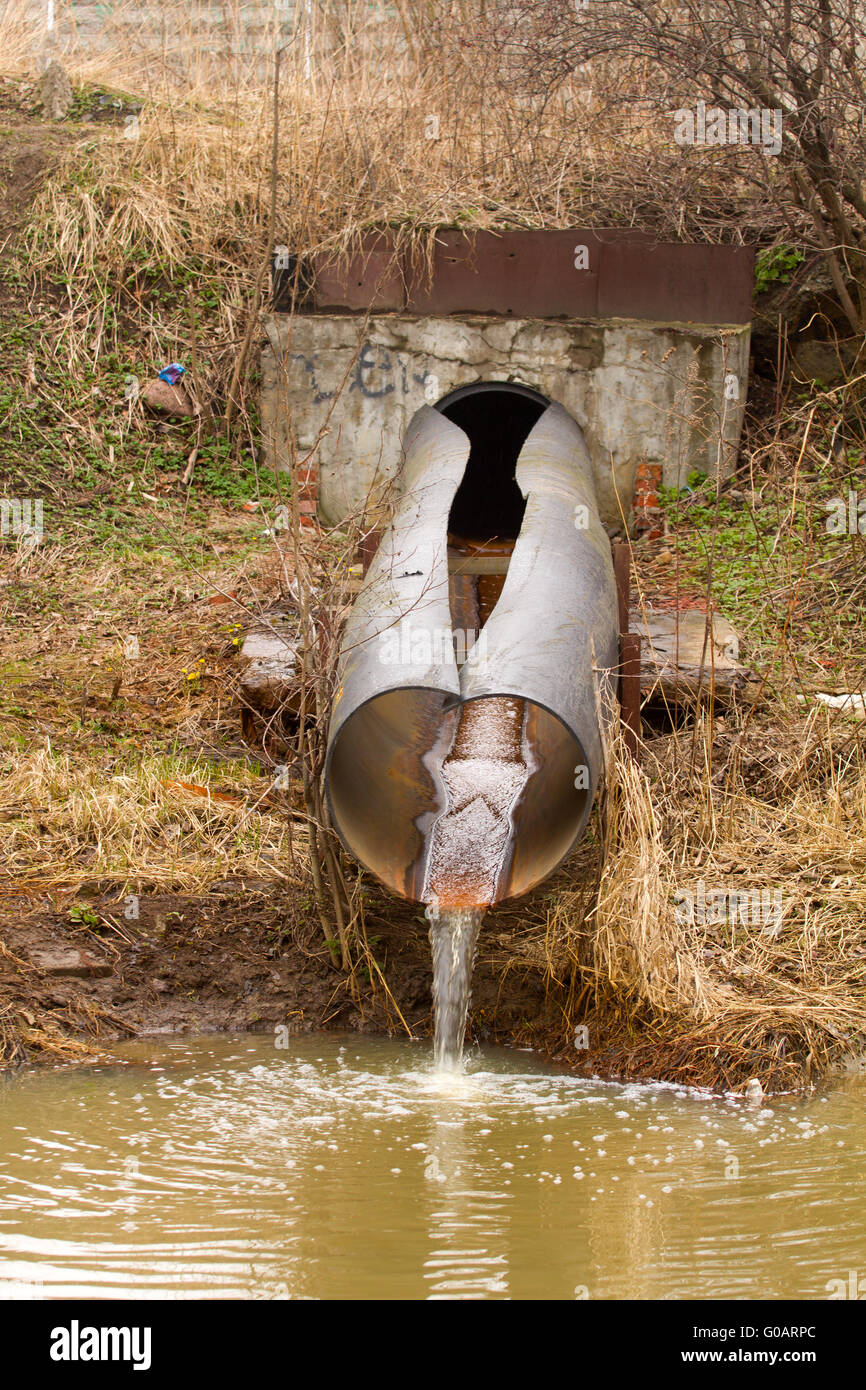 Acqua sporca verso il fiume a livello industriale da un tubo Foto Stock