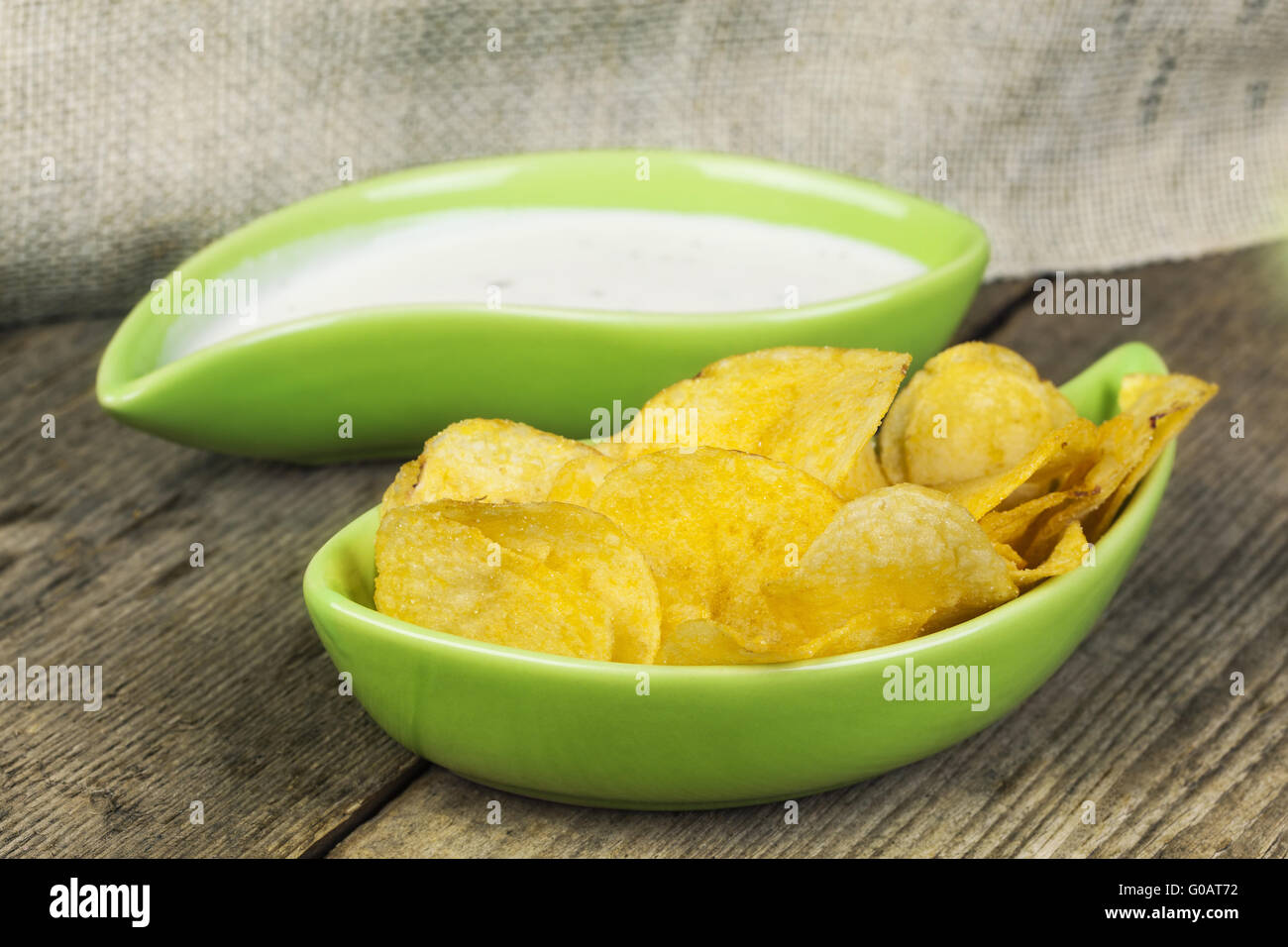 Patatine croccanti in verde ciotola sul tavolo di legno Foto Stock