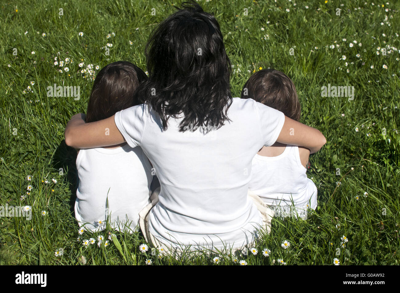 Madre di due bambini seduti sulla molla di me Foto Stock