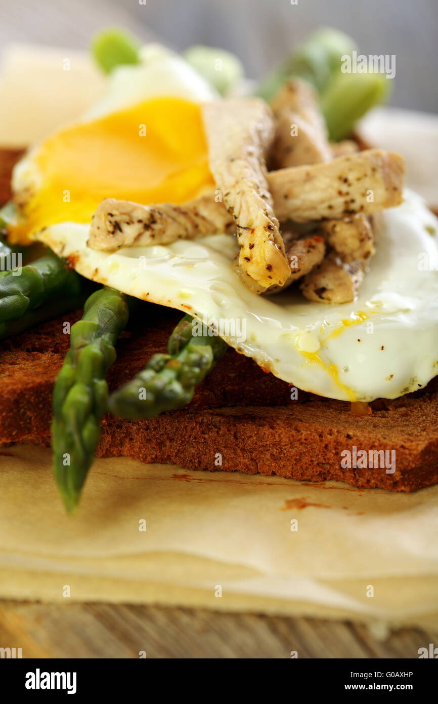 Toast con uova, asparagi verdi e la Turchia sulla vecchia scheda.. Foto Stock