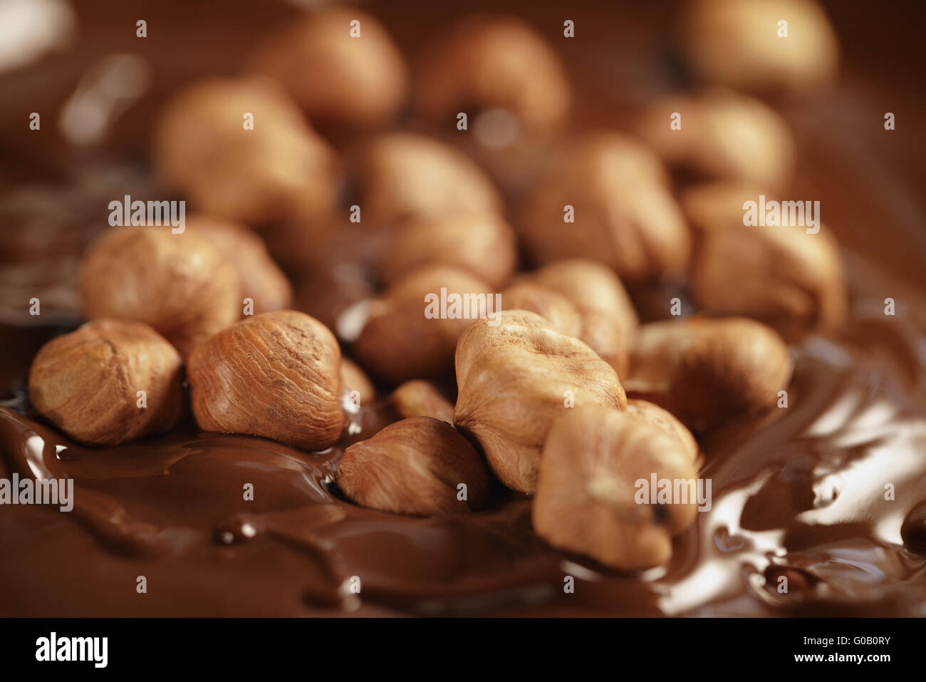 Cioccolato fondente fuso con nocciole, rendendo la barra di cioccolato Foto Stock Cioccolato fondente fuso con nocciole, rendendo la barra di cioccolato Foto Stock