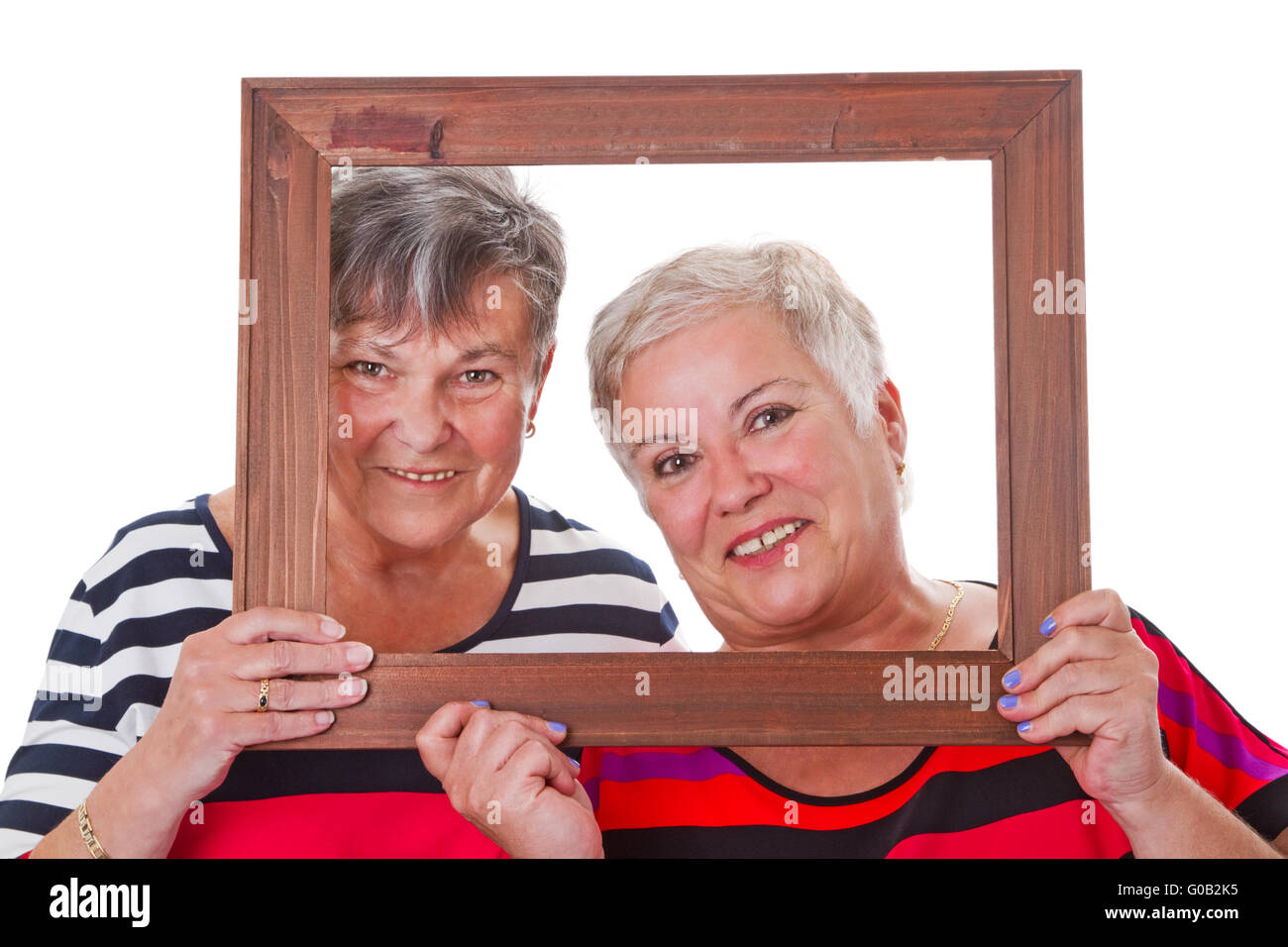 Due donne senior guardando attraverso una cornice immagine Foto Stock