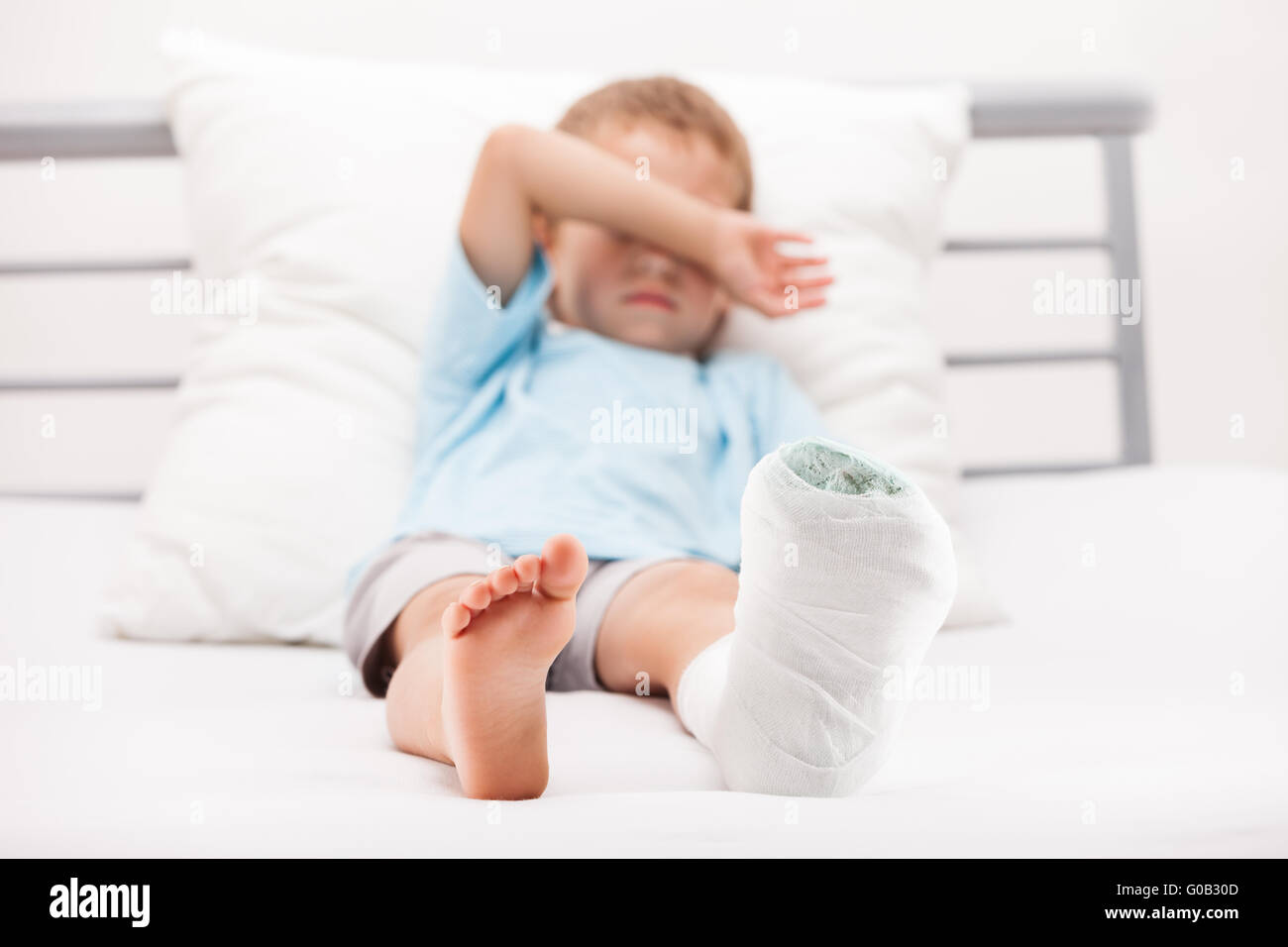 Bambino ragazzo con bendaggio in gesso sulla gamba tallone Foto Stock