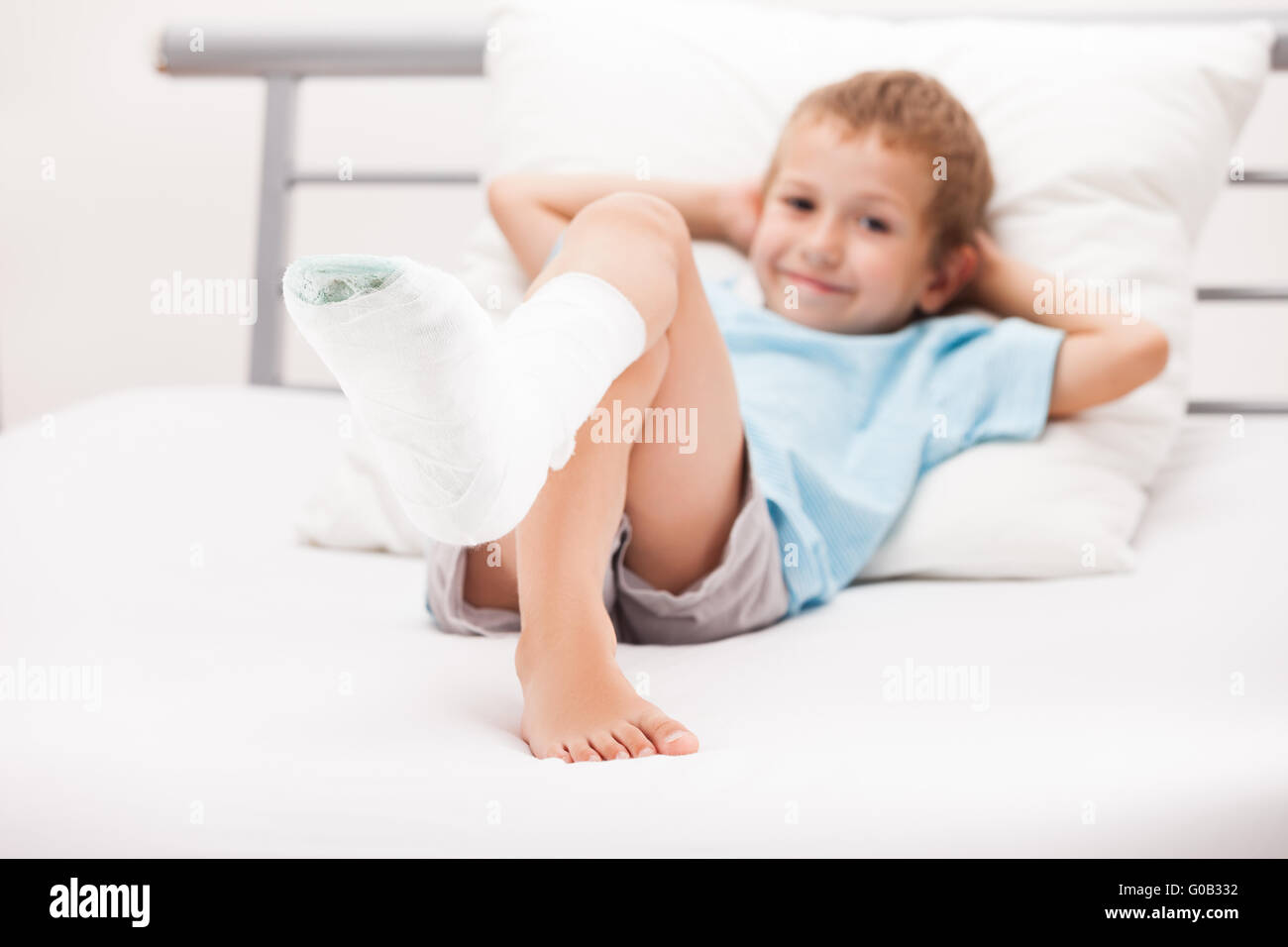 Bambino ragazzo con bendaggio in gesso sulla gamba tallone Foto Stock