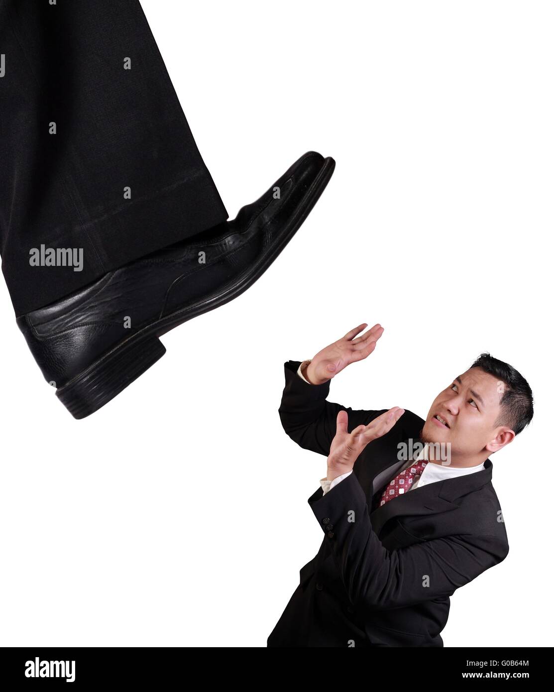 Il concetto di Business immagine di un uomo d'affari asiatici sulla tenuta sotto pressione di big boss, sotto la scarpa gigante, isolato su bianco Foto Stock