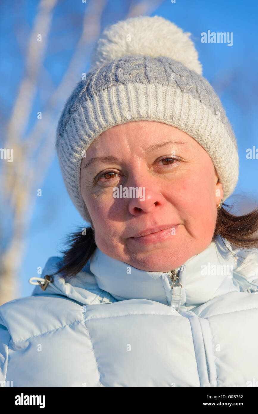 La donna della media degli anni in un bianco cappuccio a maglia Foto Stock