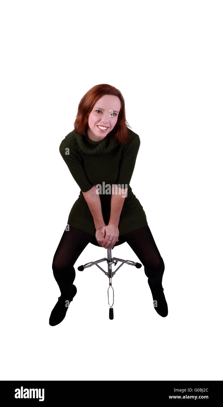 Donna sorridente vestito sporgersi in avanti sgabello Foto Stock