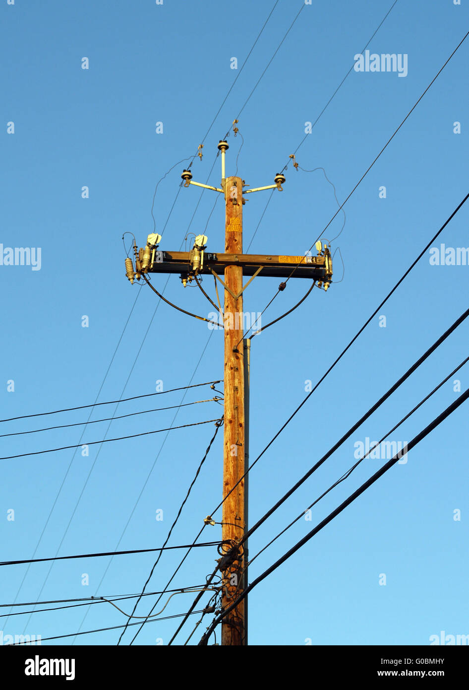 Legno palo del telefono con linee di alimentazione proveniente in molte  direzioni Foto stock - Alamy