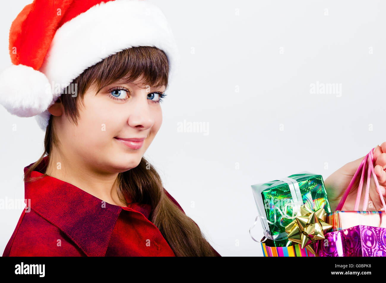 Blue-eyed bella ragazza in santa hat con presenta Foto Stock