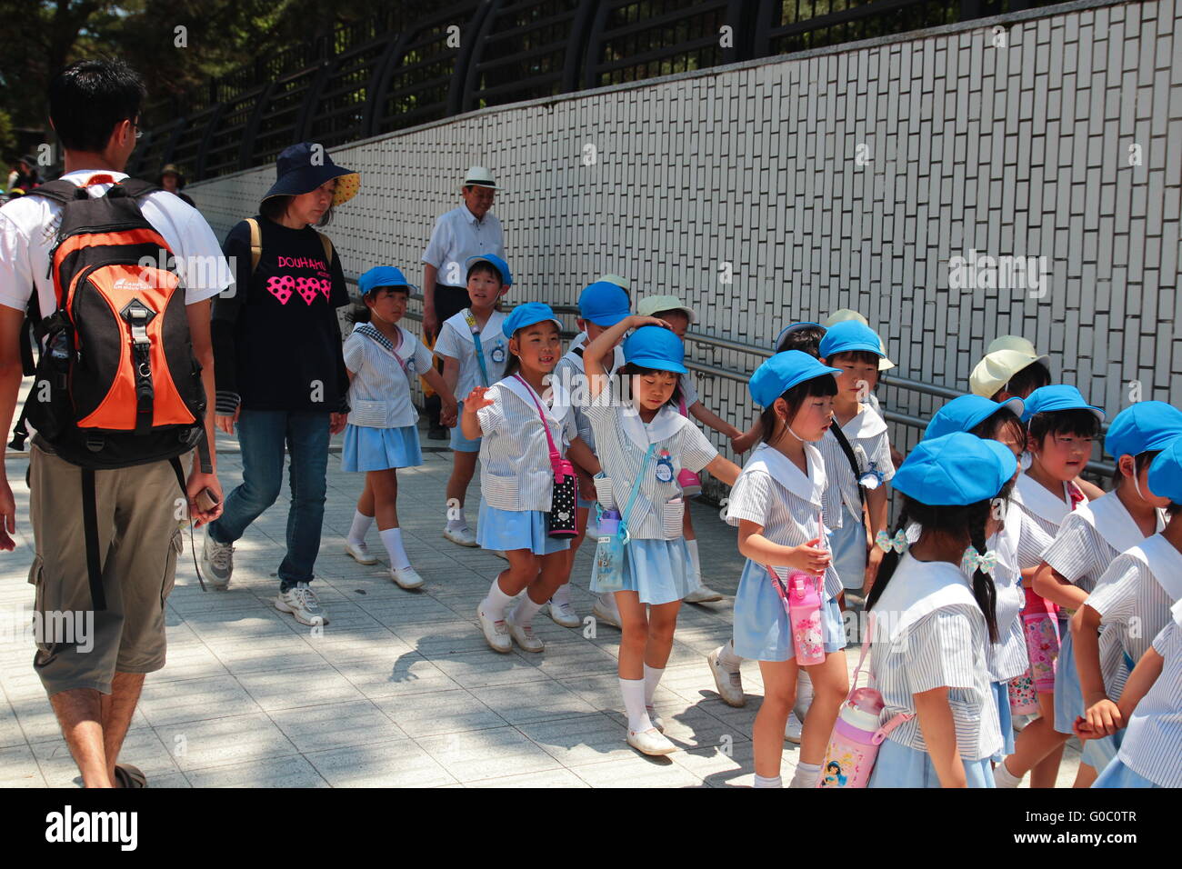 I bambini della scuola a piedi di gruppo in un parco insieme con i loro educatori. Foto Stock