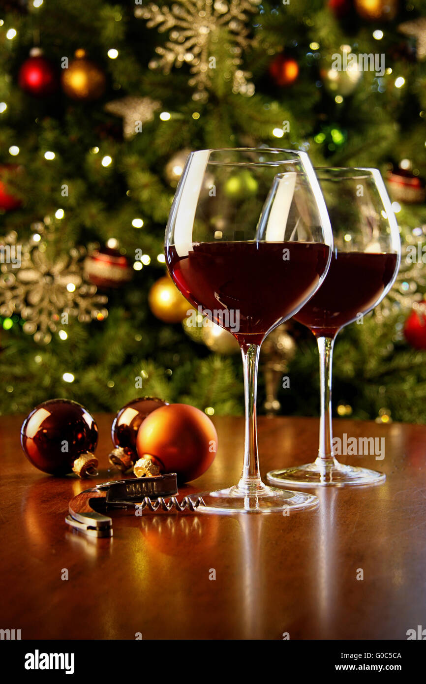 Bicchieri di vino rosso sul tavolo con albero di Natale ho Foto Stock