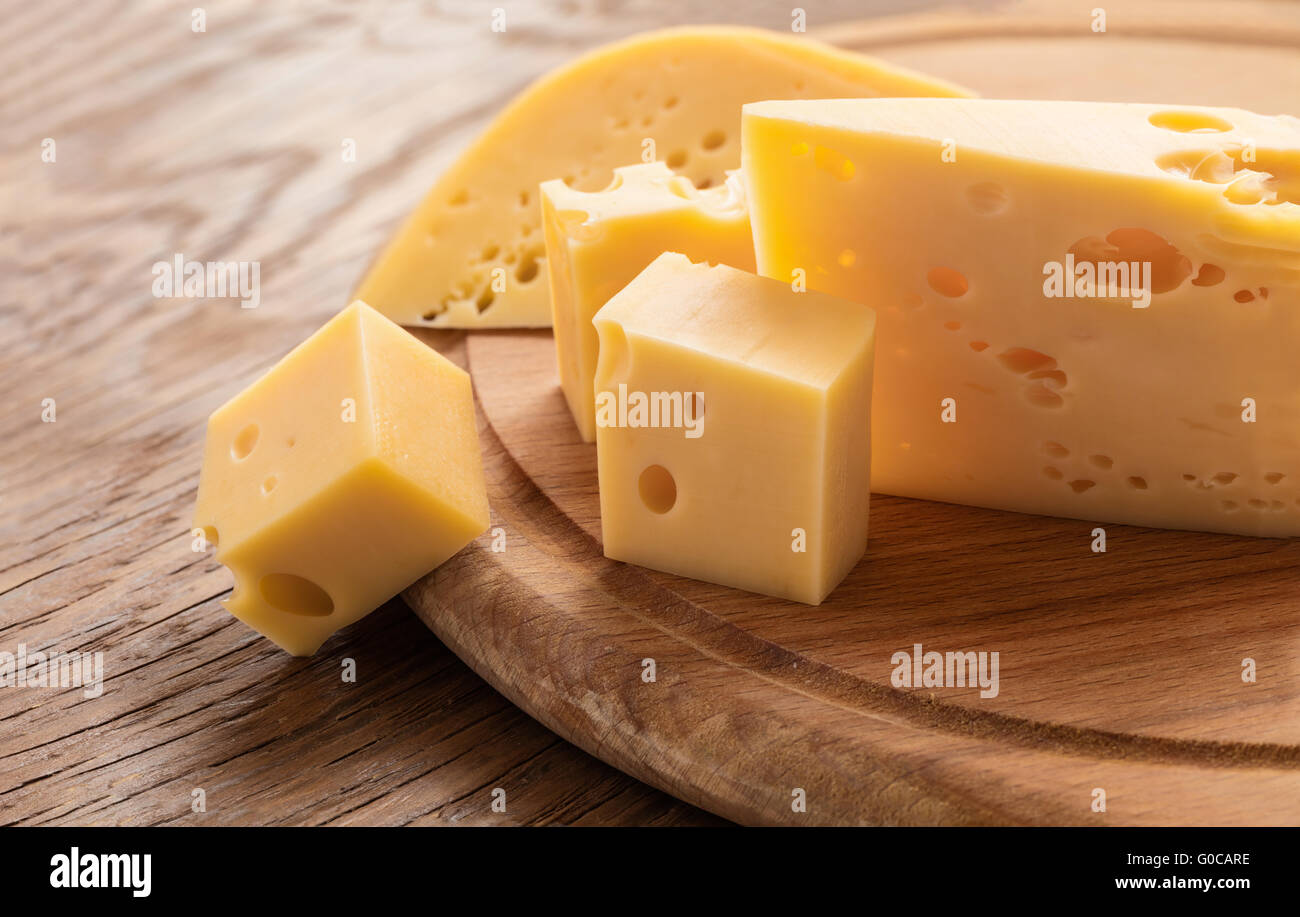 Pezzo fresco di formaggio su uno sfondo di legno Foto Stock