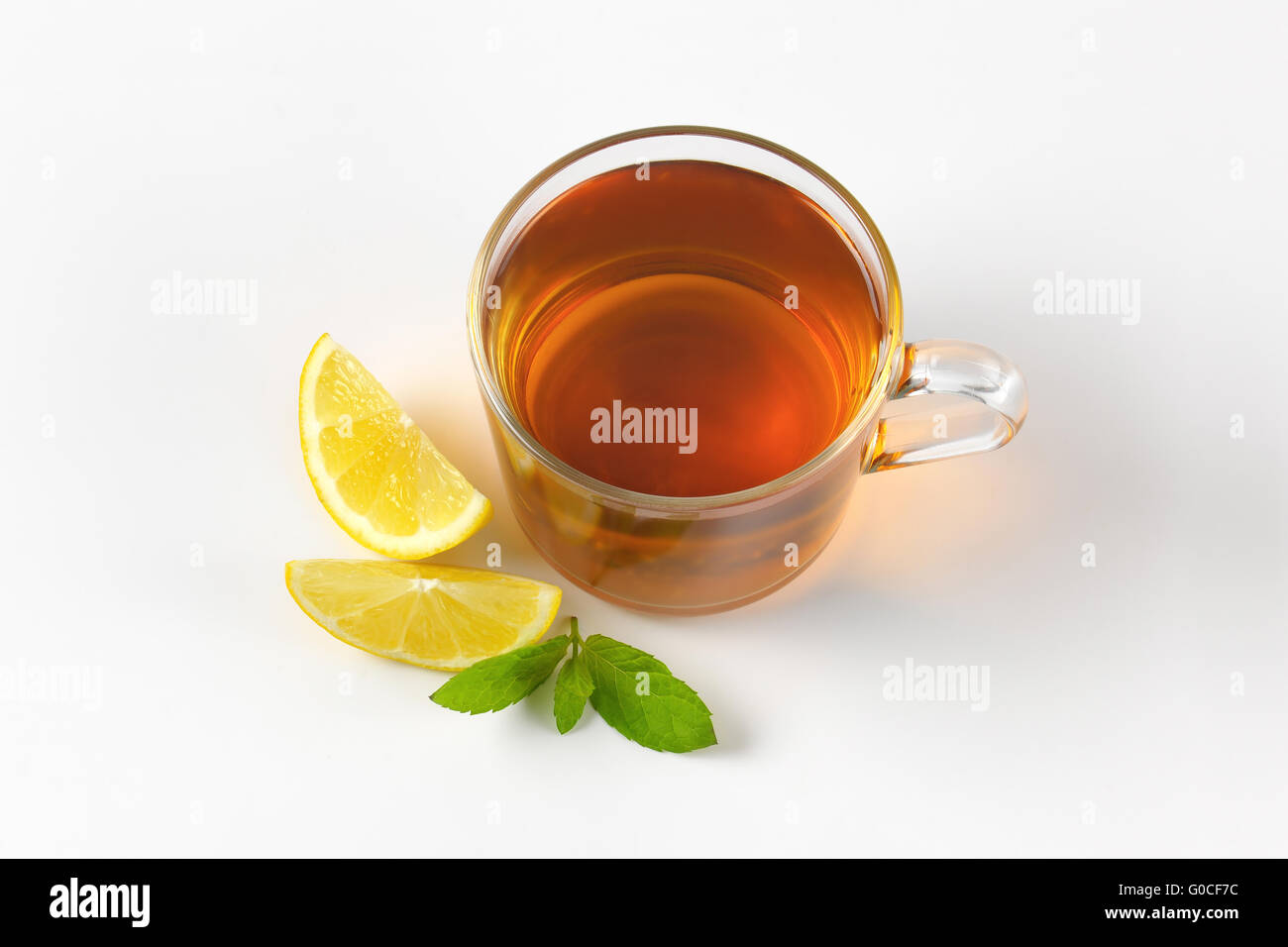 Tazza di tè nero con il limone su sfondo bianco Foto Stock