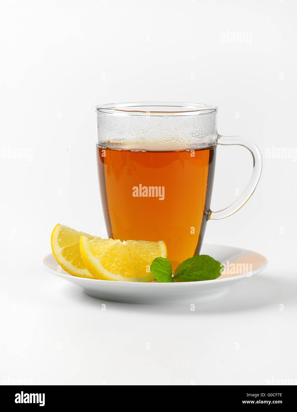 Tazza di tè nero con il limone su sfondo bianco Foto Stock