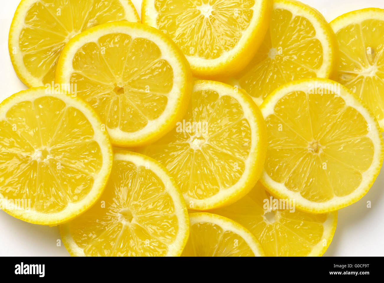 Cumulo di fettine di limone fresco su bianco Foto Stock