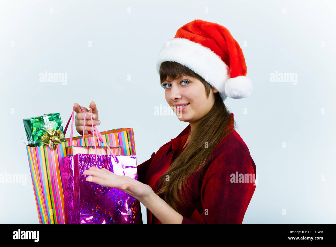 Giovane donna in santa hat con lo shopping delle feste Foto Stock