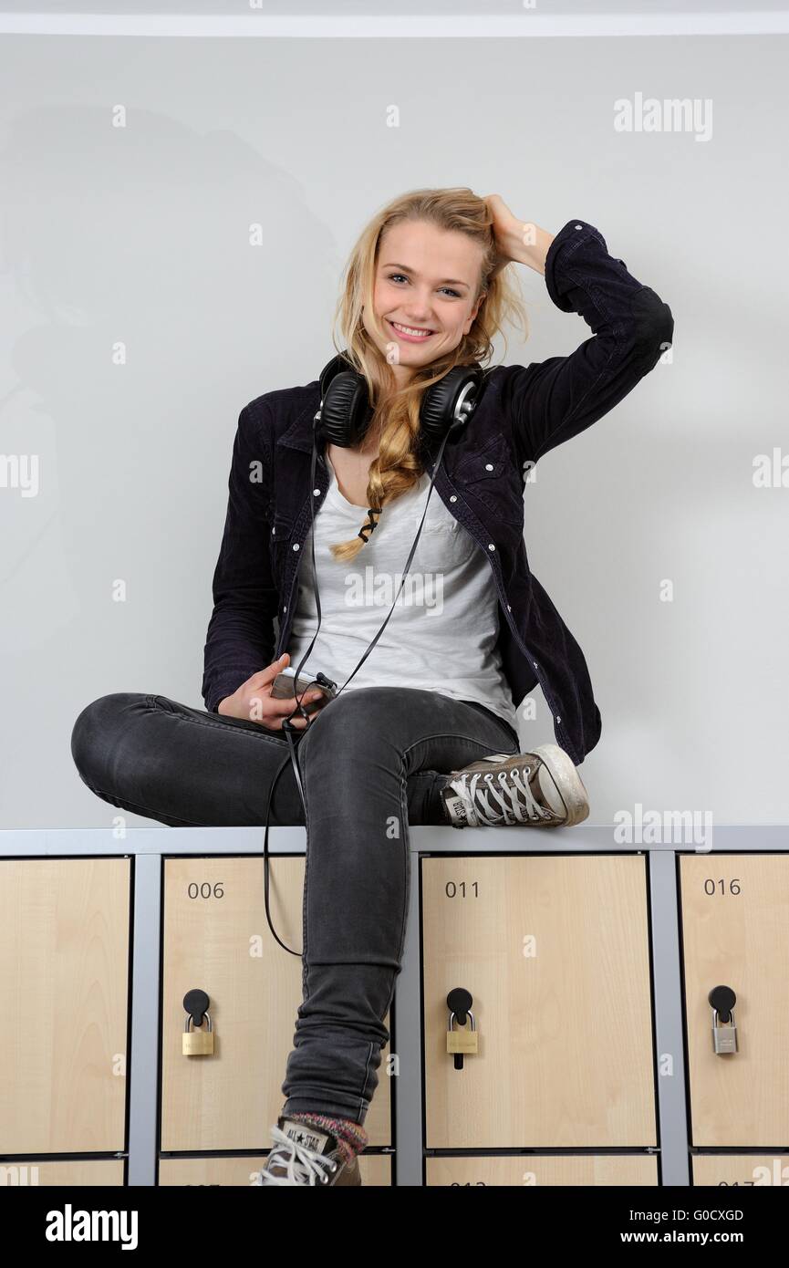 Bella femmina studente seduto su un lockbox Foto Stock